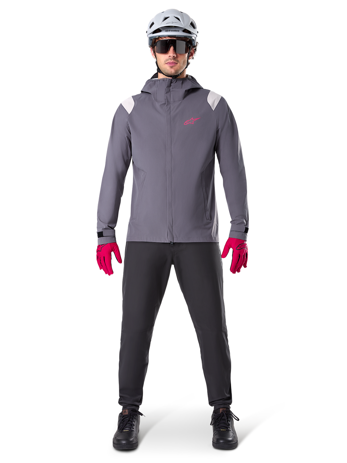 Alpinestars A-Dura Rain Jacket, casaco de BTT, cinzento Dark Titanium com logótipo cor-de-rosa, usado com capacete de BTT cinzento e luvas cor-de-rosa vibrante, design com membrana protetora de 2,5 camadas para ciclismo em tempo de chuva