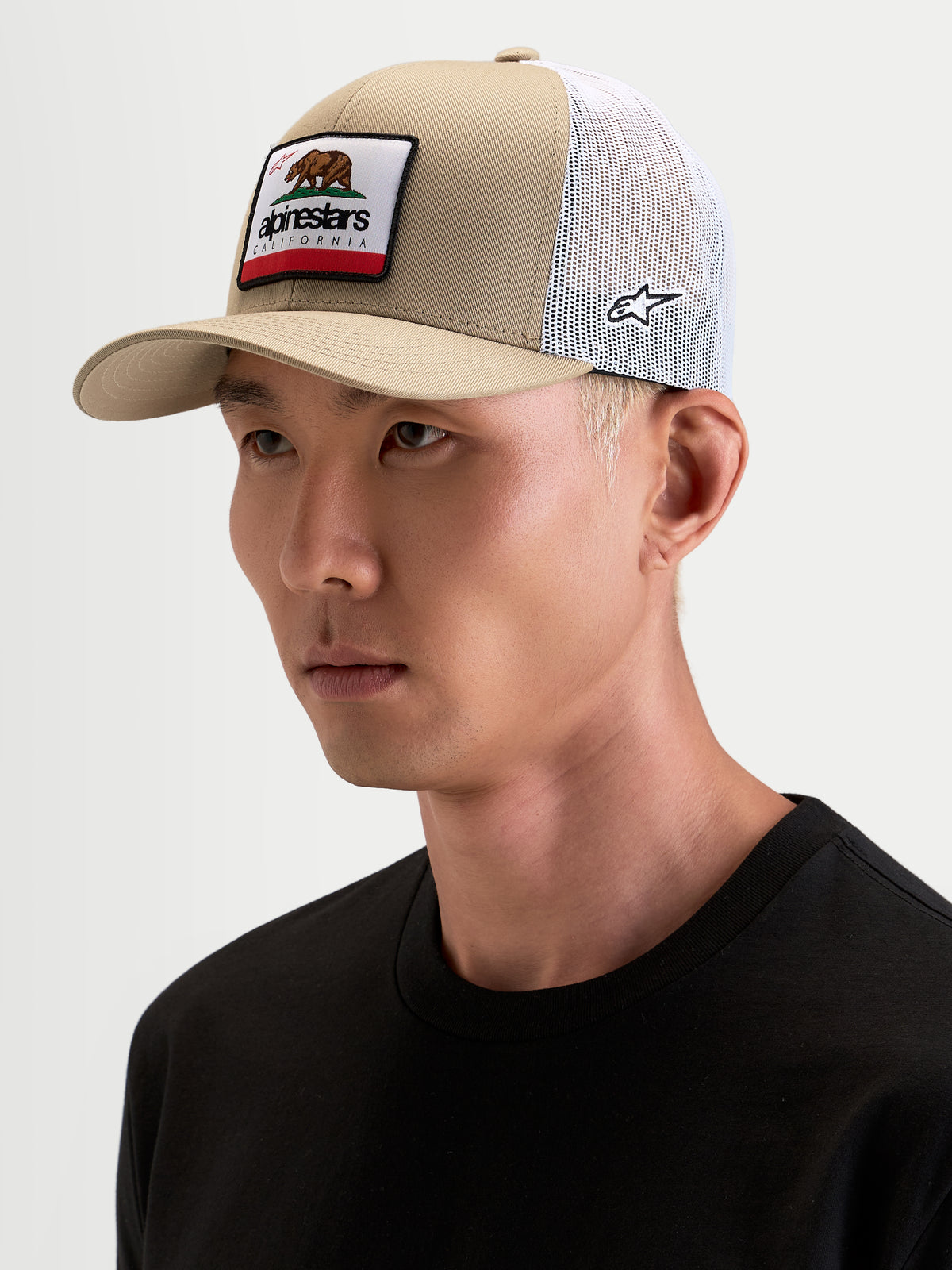 Alpinestars Chapéu Cali 2.0, boné trucker sportswear, caqui e branco, num modelo, com aba curva, coroa estruturada em sarja, malha respirável atrás e patch tecido da Califórnia na frente