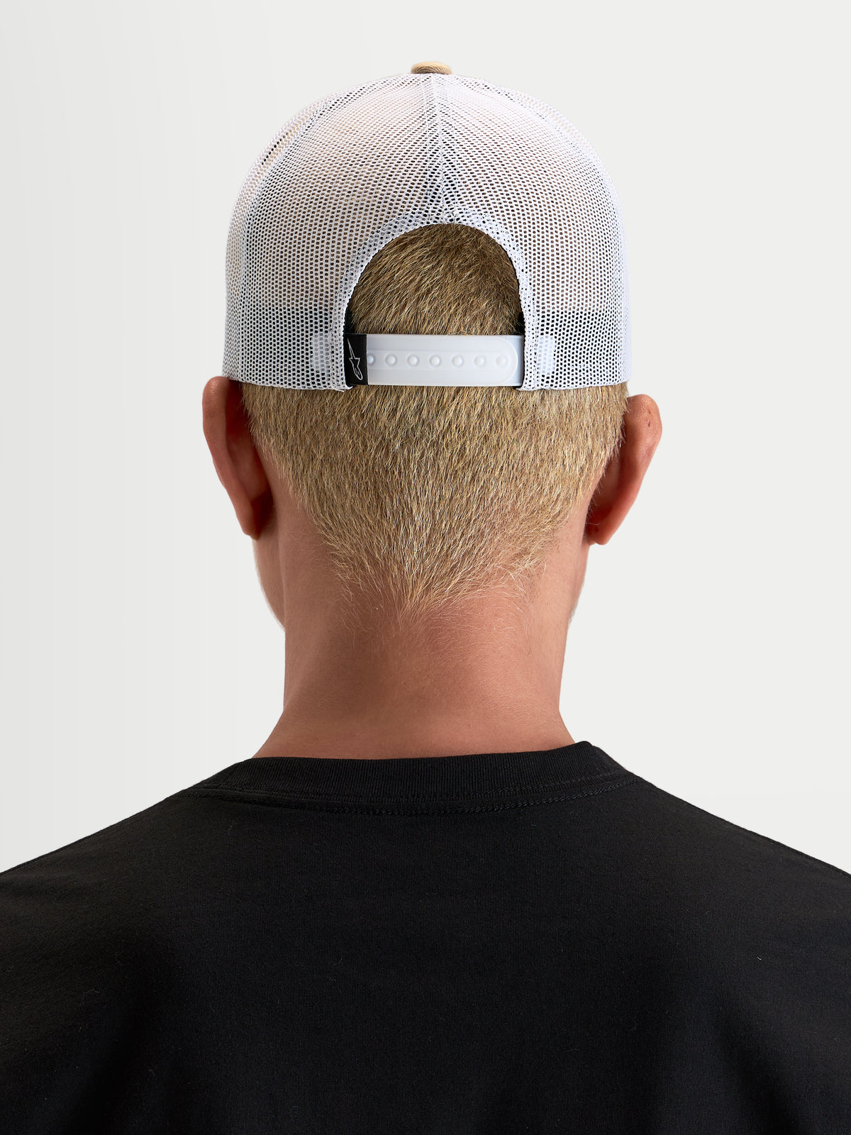 Chapéu Cali 2.0 da Alpinestars, boné trucker sportswear unissexo, caqui e branco, vista traseira num modelo a mostrar o fecho snapback ajustável e a malha branca respirável
