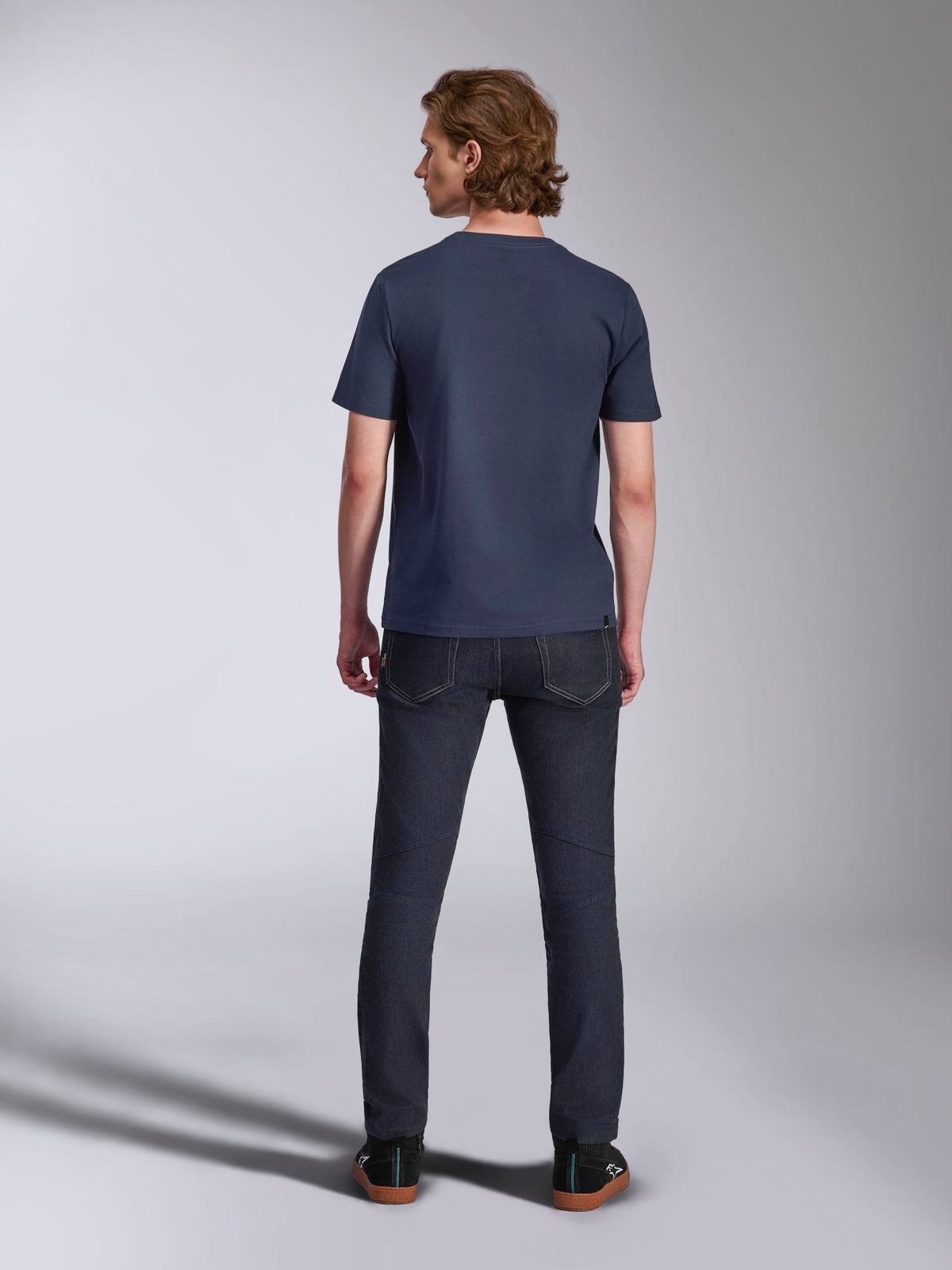 Alpinestars Ageless 2.0 CSF Tee, t-shirt de manga curta, azul-marinho, vista de costas, usada por um homem com calças de ganga escuras e sapatilhas pretas, streetwear casual inspirado no desporto motorizado