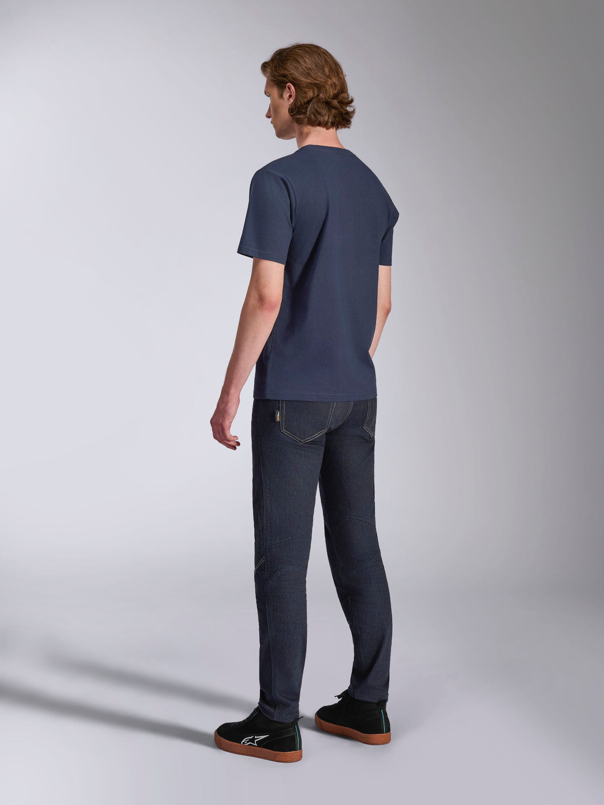 Alpinestars Ageless 2.0 CSF Tee, t-shirt de manga curta, azul-marinho, vista de costas, usada com calças de ganga escuras e sapatilhas pretas, streetwear casual de desportos motorizados