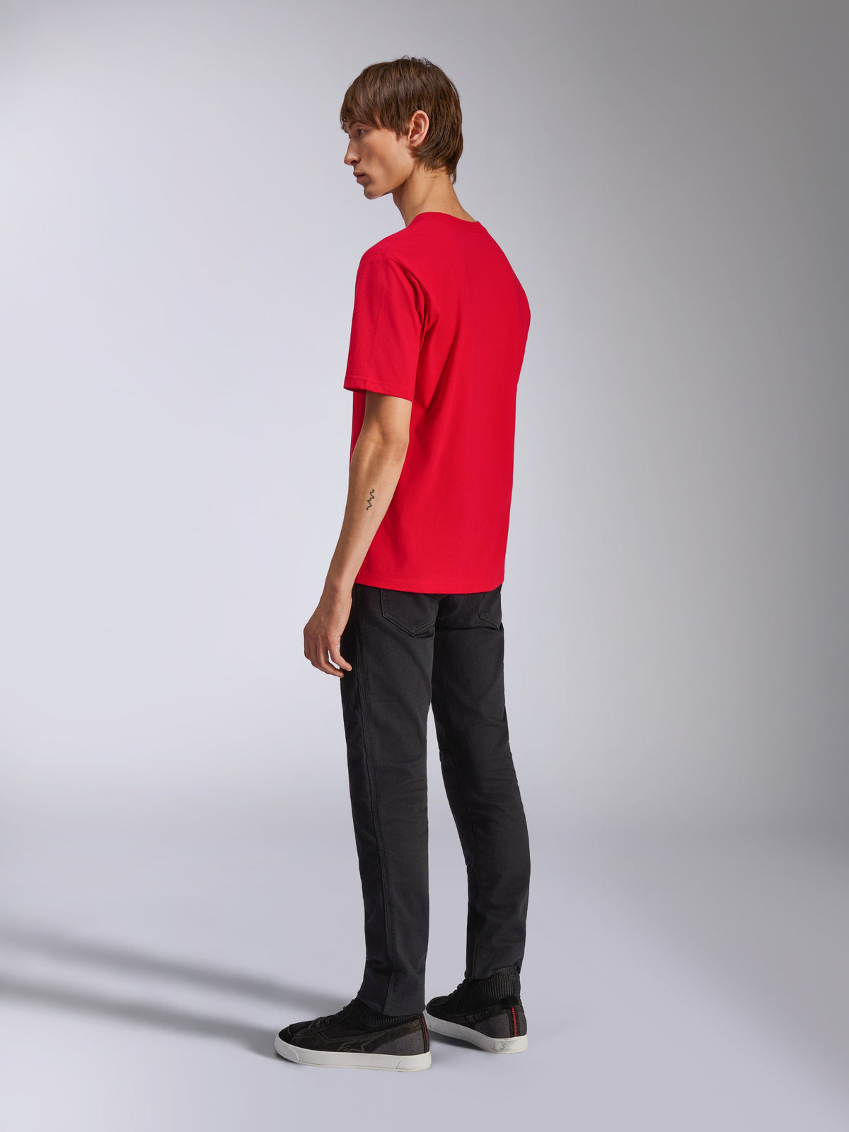 Alpinestars T-shirt Ageless Shadow CSF, t-shirt de manga curta vermelha, vista de costas no modelo, usada com calças pretas e sapatilhas, streetwear casual inspirado no desporto motorizado