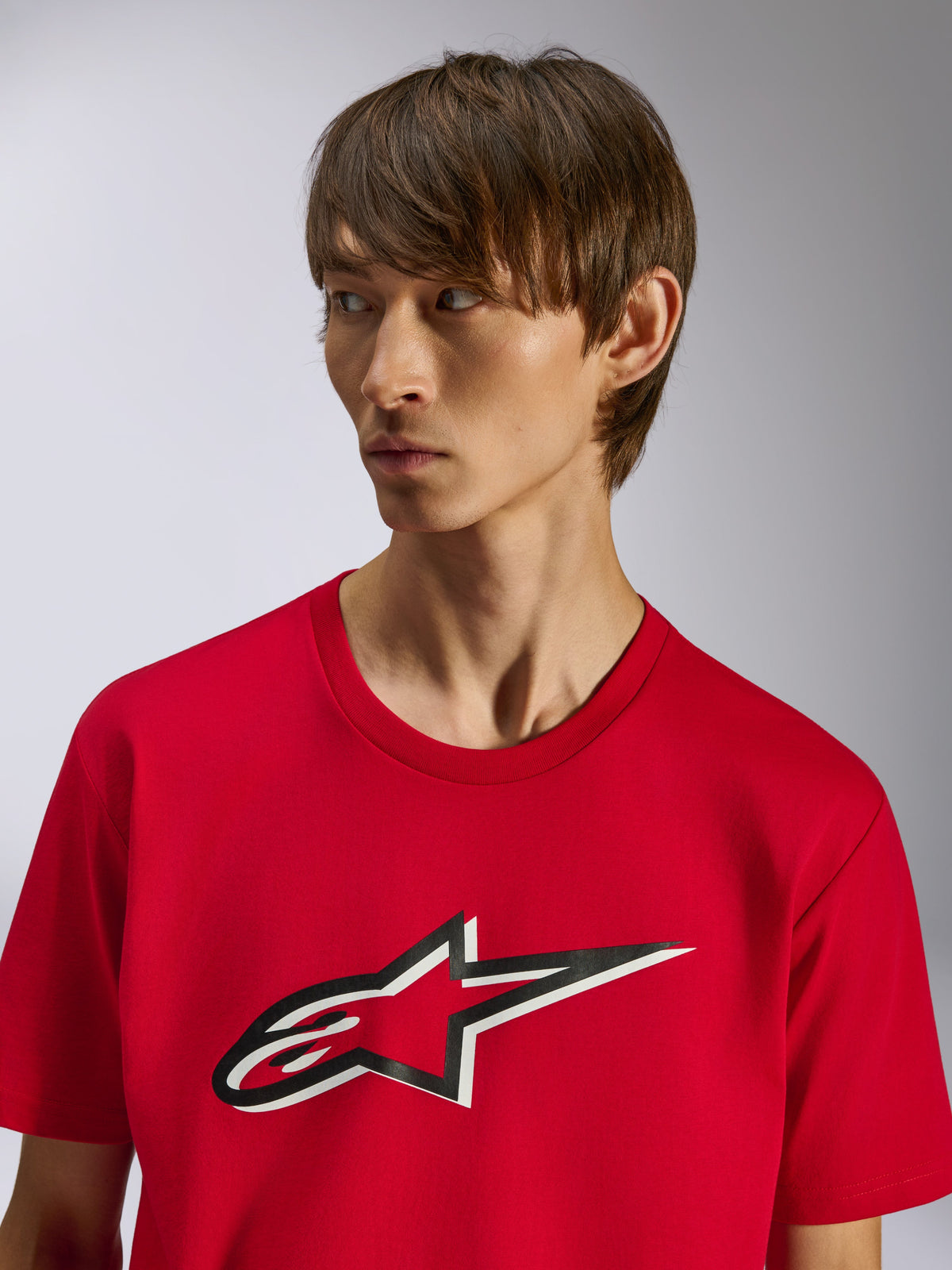 Alpinestars Ageless Shadow CSF Tee, t-shirt de manga curta, vermelha, logótipo frontal da estrela Ageless com efeito de sombra a preto e branco, vestida por um modelo, design casual inspirado no desporto motorizado