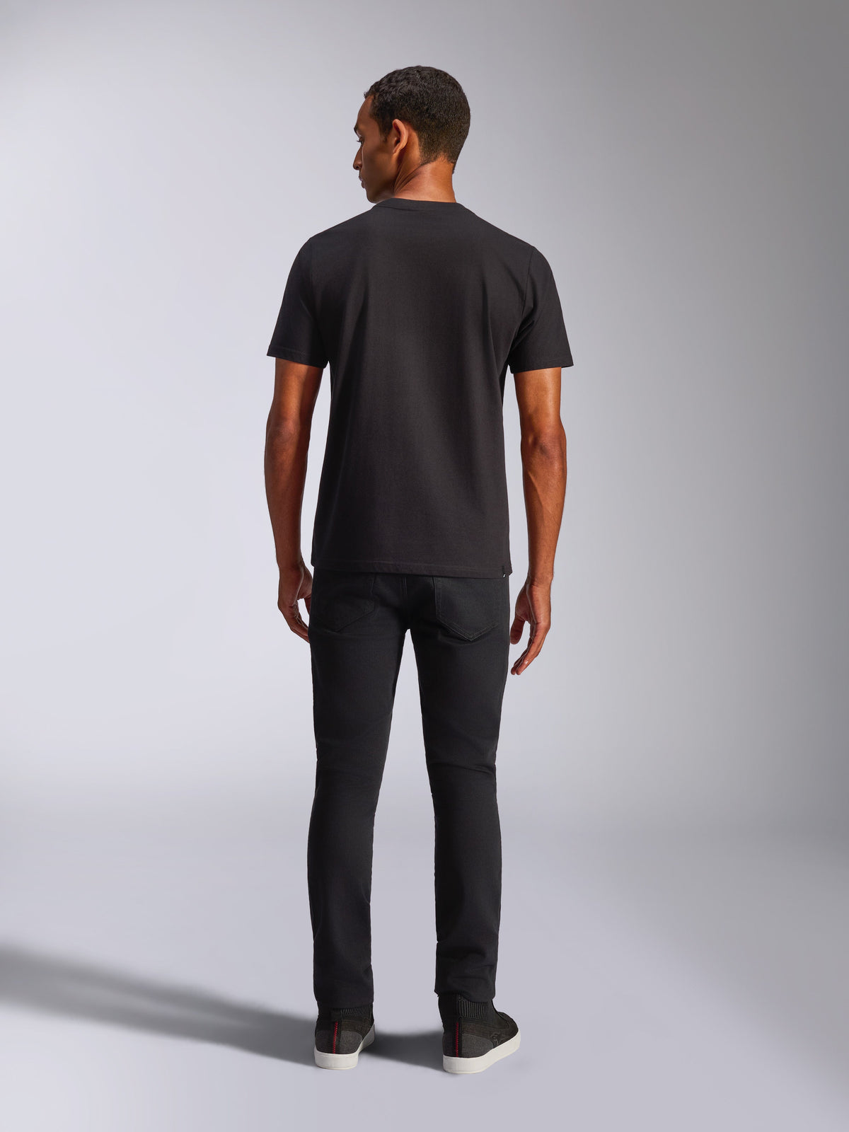 Alpinestars Blaze 2.0 CSF Tee, T-shirt de manga curta, preta, vista traseira, usada com calças de ganga pretas, streetwear casual inspirado no desporto motorizado