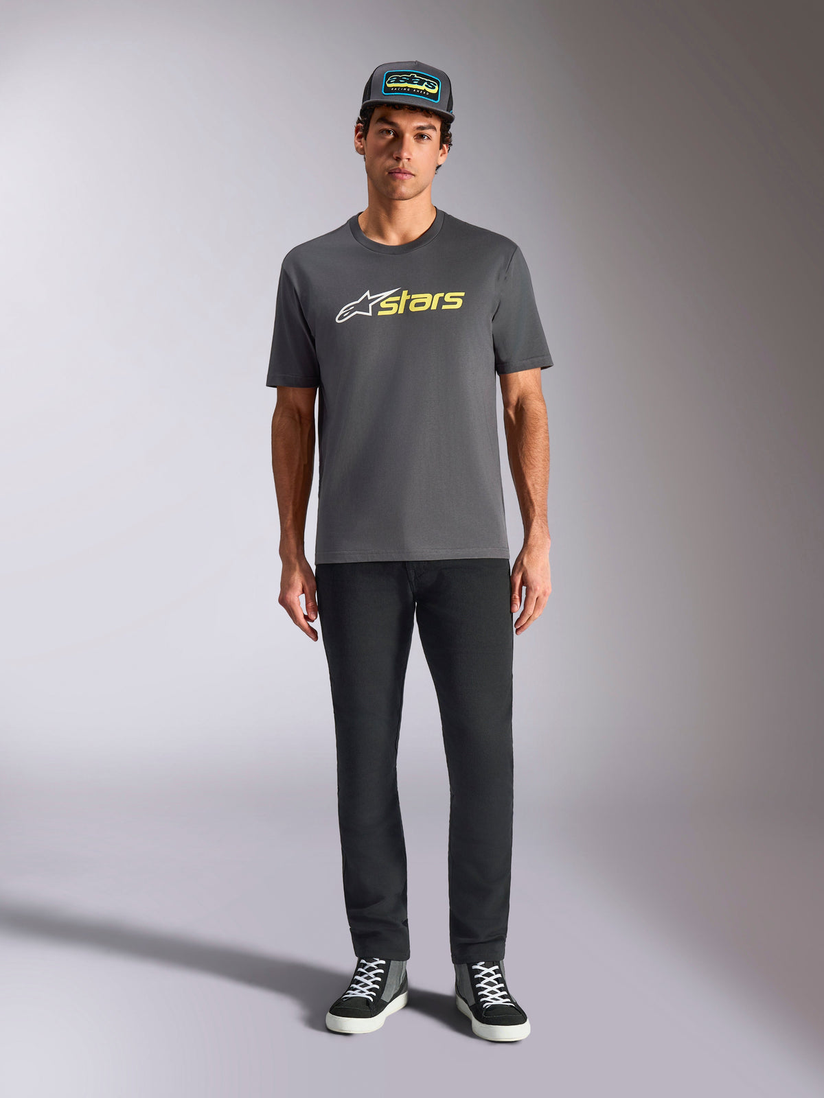 Alpinestars Blaze 2.0 CSF Tee, t-shirt de manga curta, cinzento antracite com logótipo branco e amarelo néon, usada com calças pretas e boné trucker a condizer, estilo casual de desportos motorizados