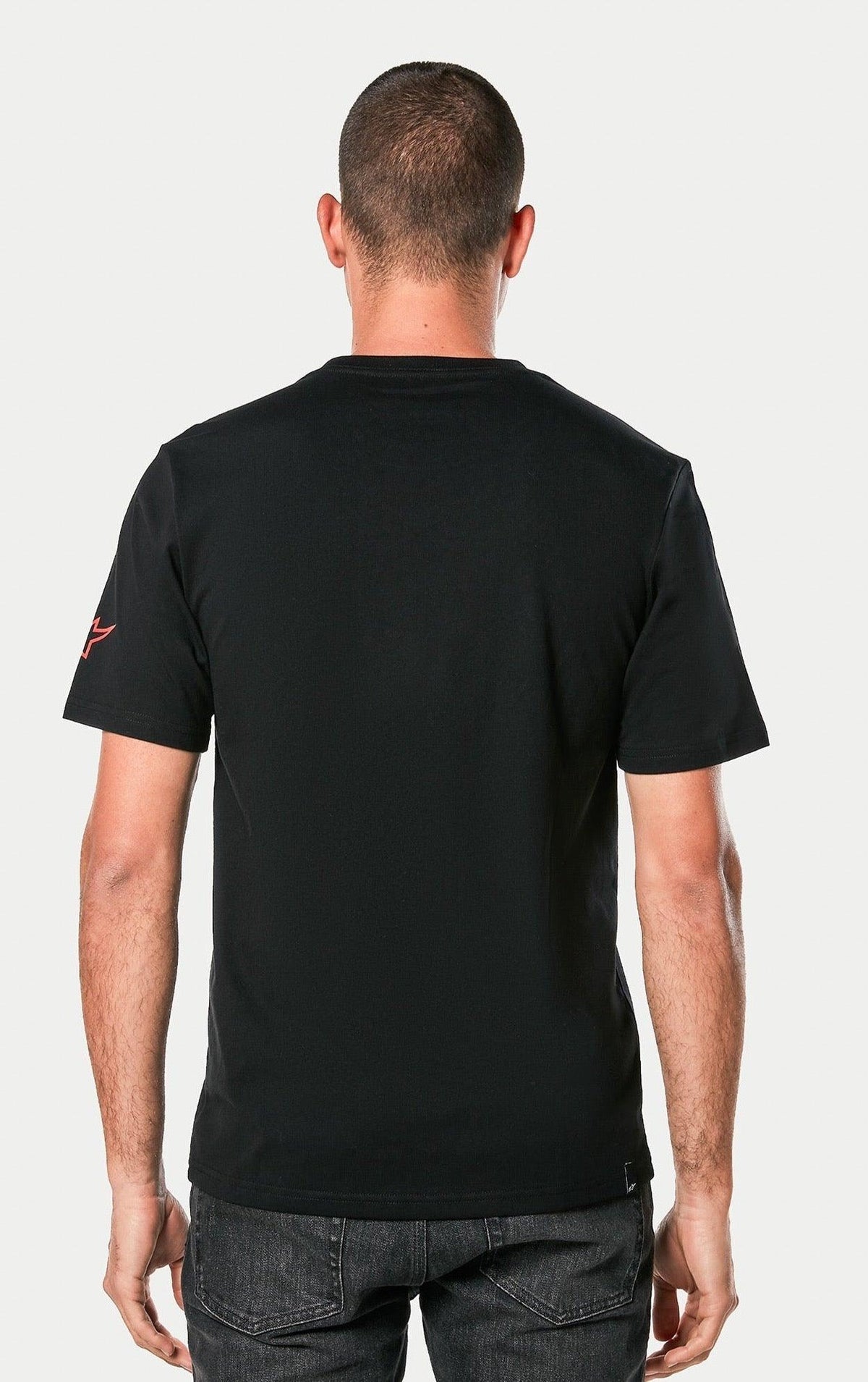 Alpinestars Linear Wordmark 2.0 CSF Tee, preta, vista traseira de uma pessoa a usar a T-shirt de manga curta, com o logótipo Ageless vermelho na manga, streetwear casual de desportos motorizados