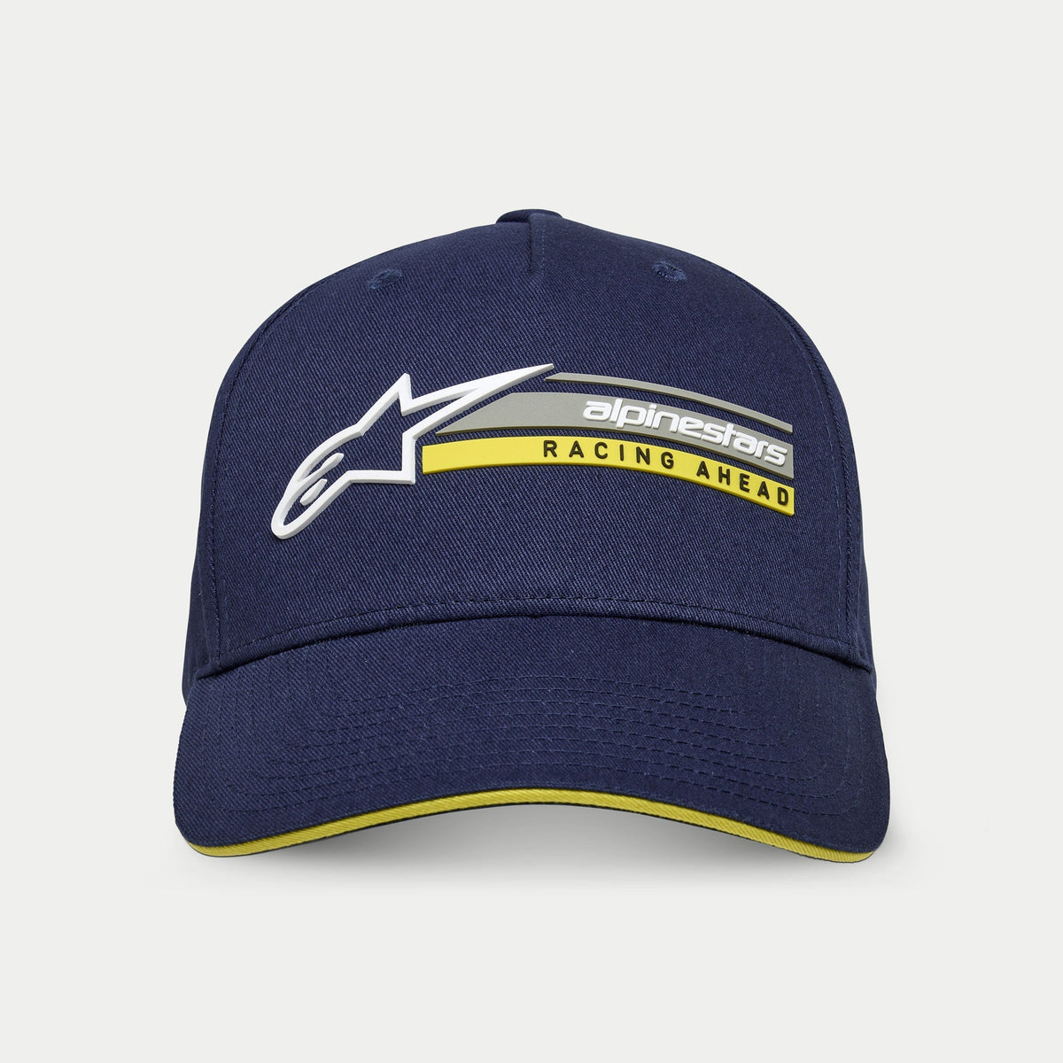 Alpinestars Par Hat, Navy Blue, structured snapback cap with curved bill, featuring 3D white Astars logo and 'alpinestars RACING AHEAD' graphic in grey and yellow, yellow sandwich bill accent, casual motorsport streetwear