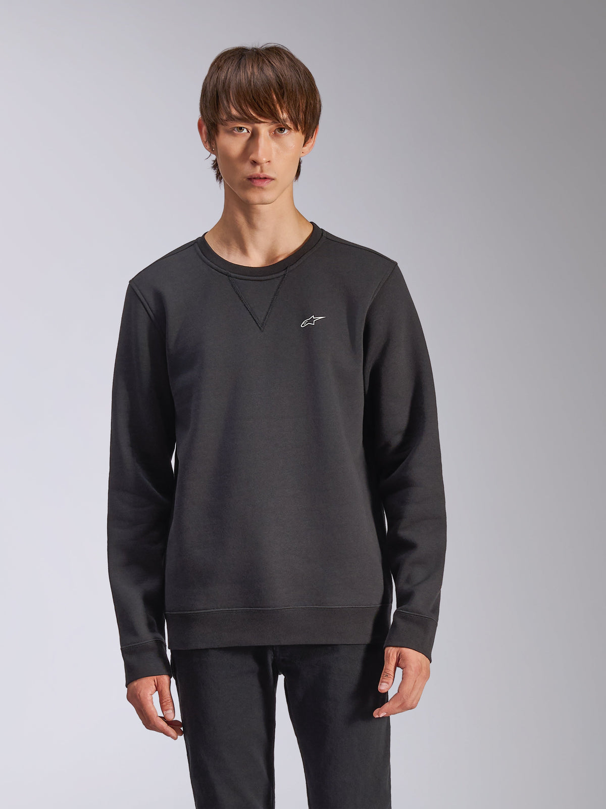 Camisola Alpinestars Positive Crew, preta, com um pequeno logótipo de estrela Alpinestars branco no peito, detalhe de costura em V na gola redonda, punhos e bainha canelados, streetwear casual de inspiração motorsport