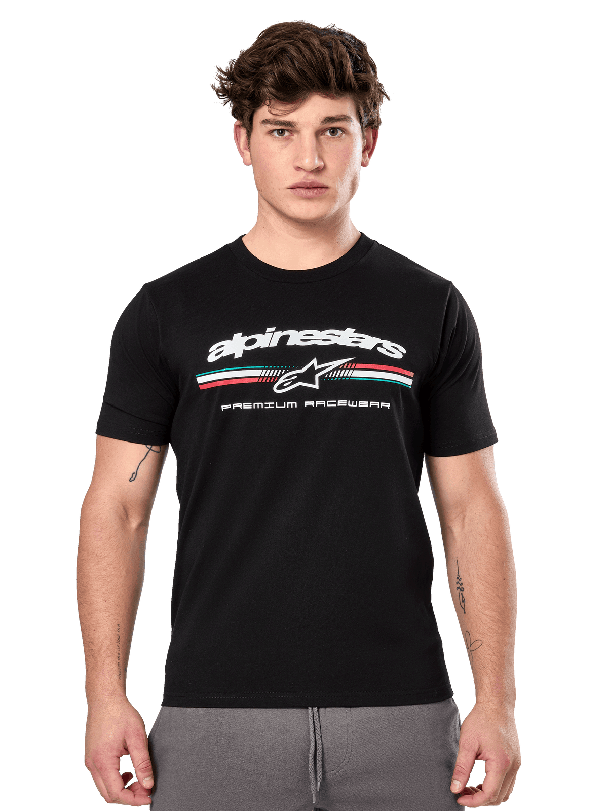 Alpinestars Prevail CSF Tee, t-shirt preta de manga curta vestida por um modelo, com logótipo branco, risca tricolor e grafismo "PREMIUM RACEWEAR", streetwear casual de desportos motorizados