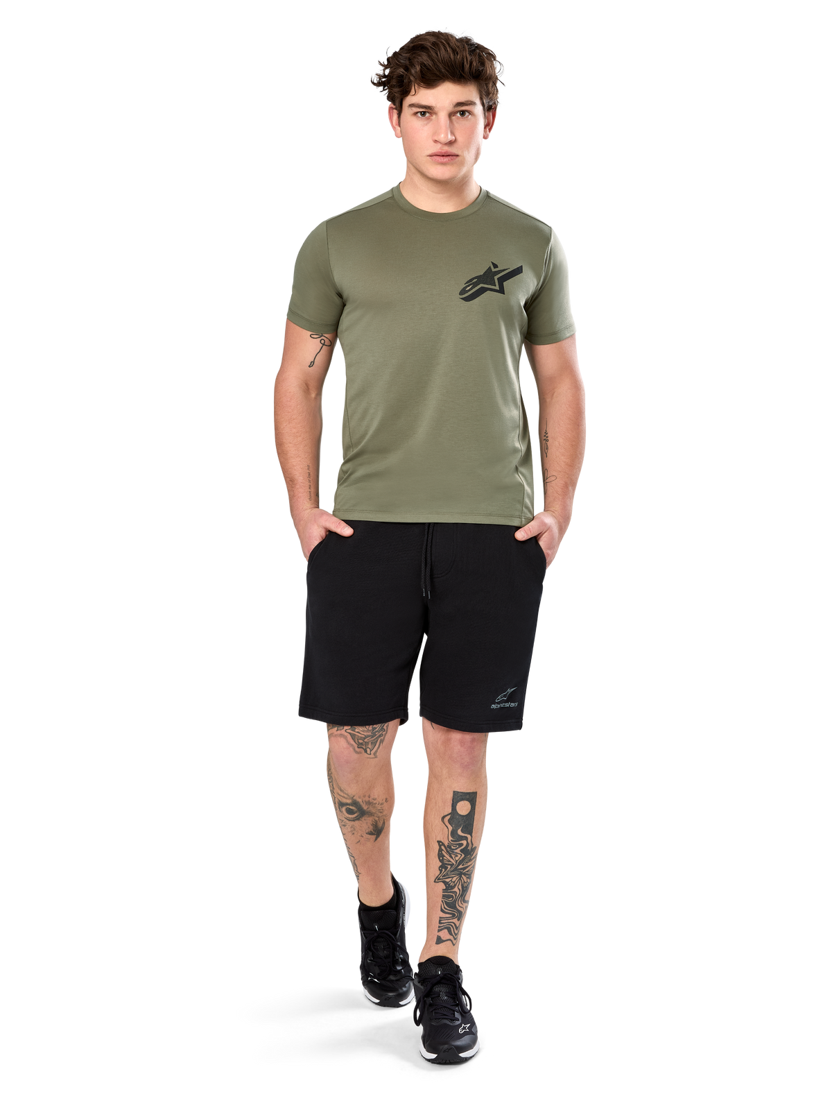 Alpinestars Attrition Performance Tee, t-shirt de manga curta, verde-claro, com logótipo Astars preto no peito, usada com calções desportivos pretos e sapatilhas pretas, fotografia de estilo de vida de vestuário desportivo casual de performance
