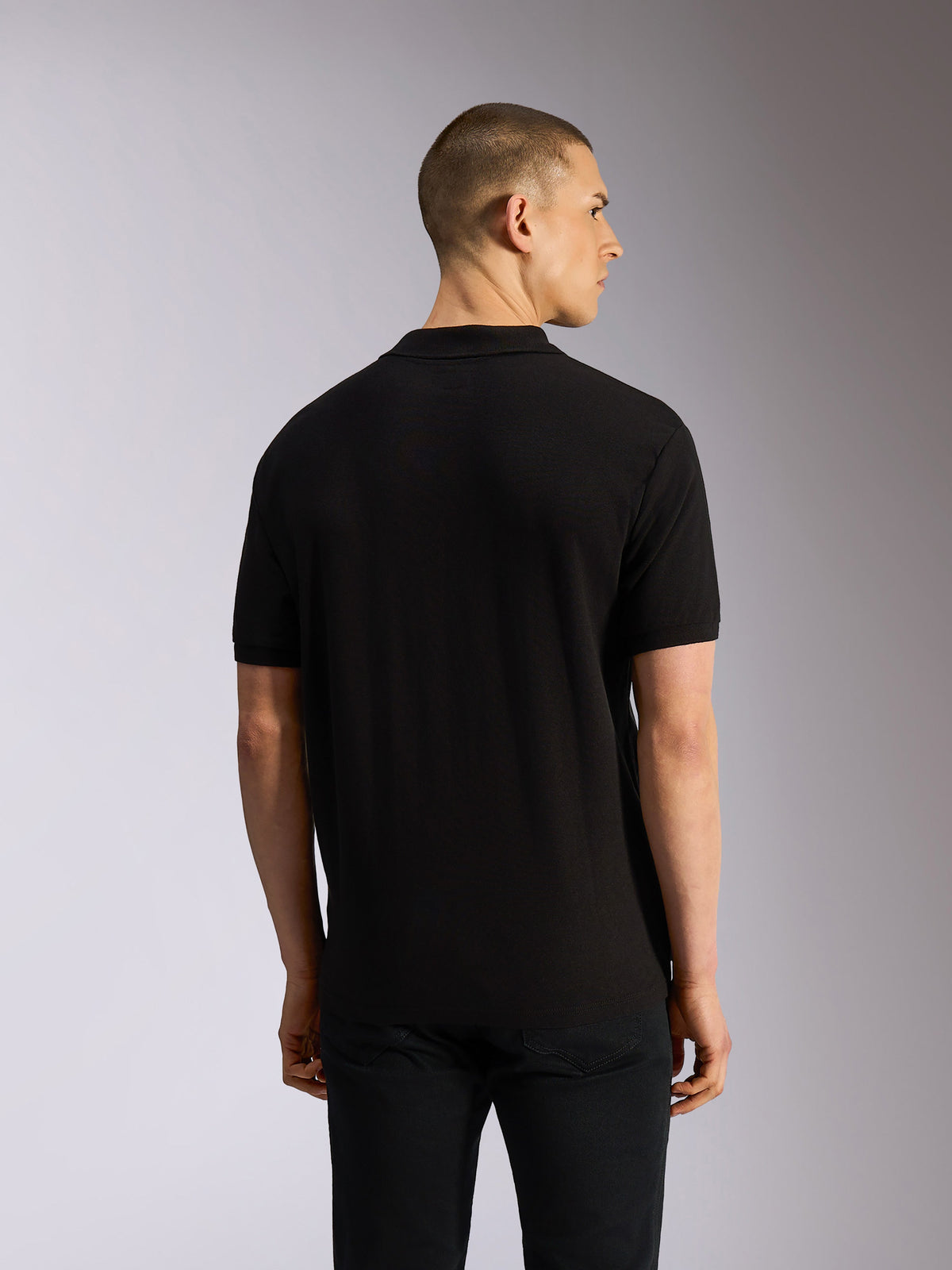 Polo Alpinestars Endeavor Classic, polo de manga curta, preto, vista traseira no modelo, malha piqué clássica com gola e punhos canelados, vestuário casual inspirado no desporto motorizado