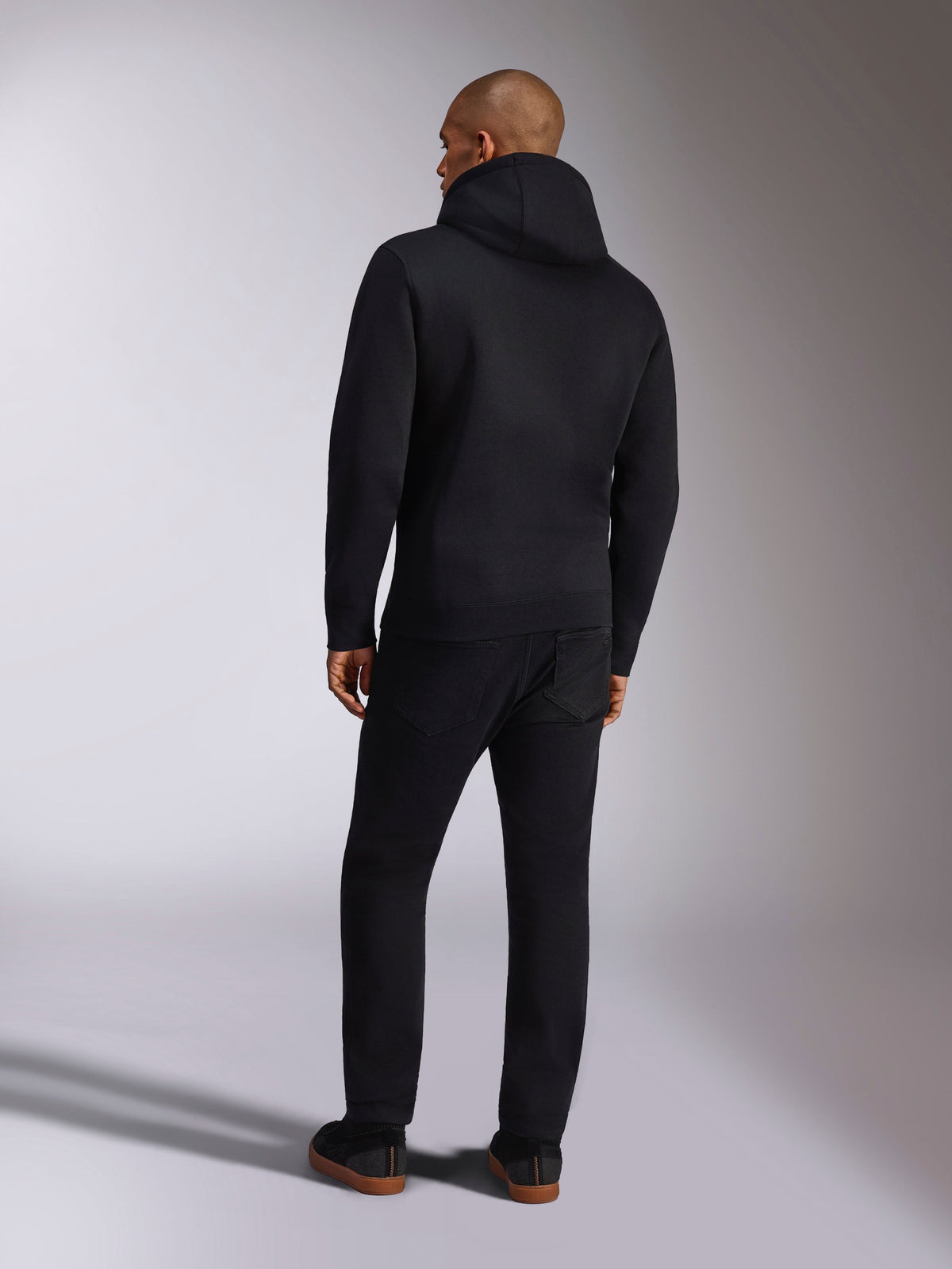 Camisola com Capuz Alpinestars Ellipsoid, sportswear casual, fleece pullover preto liso com capuz, vista traseira, com mangas compridas e bainha canelada, combinada com calças pretas, design moderno inspirado no desporto motorizado
