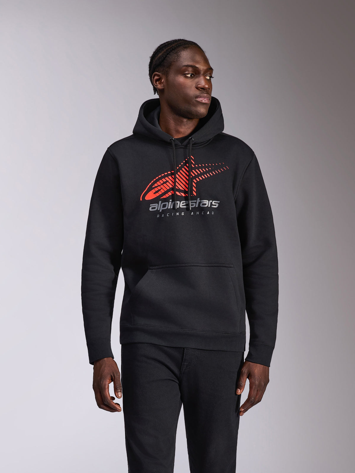 Alpinestars Pulse Hoodie, camisola casual com capuz, preta com logótipo Astars vermelho e cinzento com efeito speed line fade e texto 'Racing Ahead', capuz com cordão e bolso canguru, streetwear inspirado no desporto motorizado vestido por um modelo