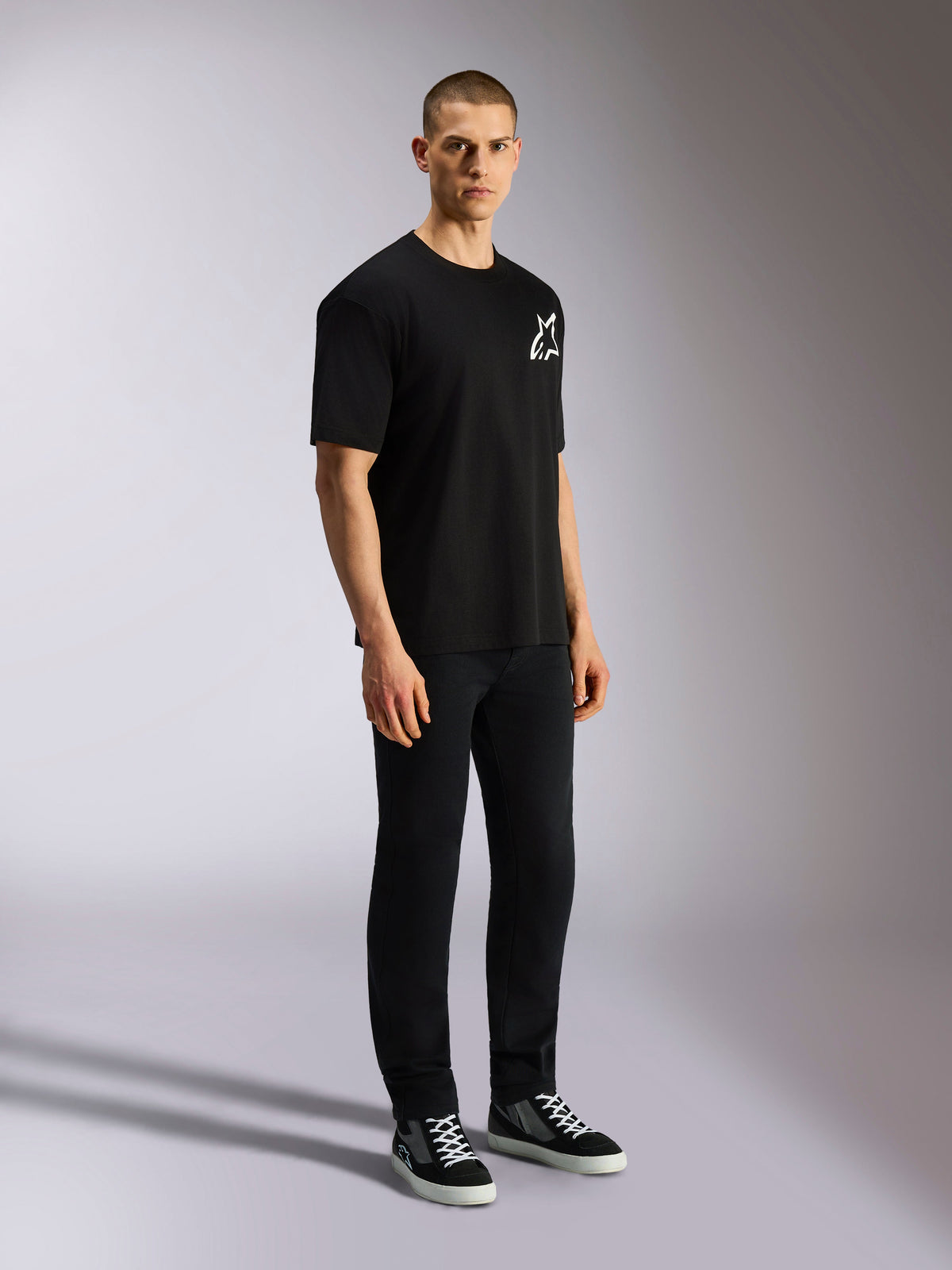 Alpinestars One Oversized CSF Tee, t-shirt de manga curta, preta, logótipo Astars branco no peito, corte oversized, usada por um modelo masculino com calças pretas e sapatilhas, streetwear casual inspirado no desporto motorizado