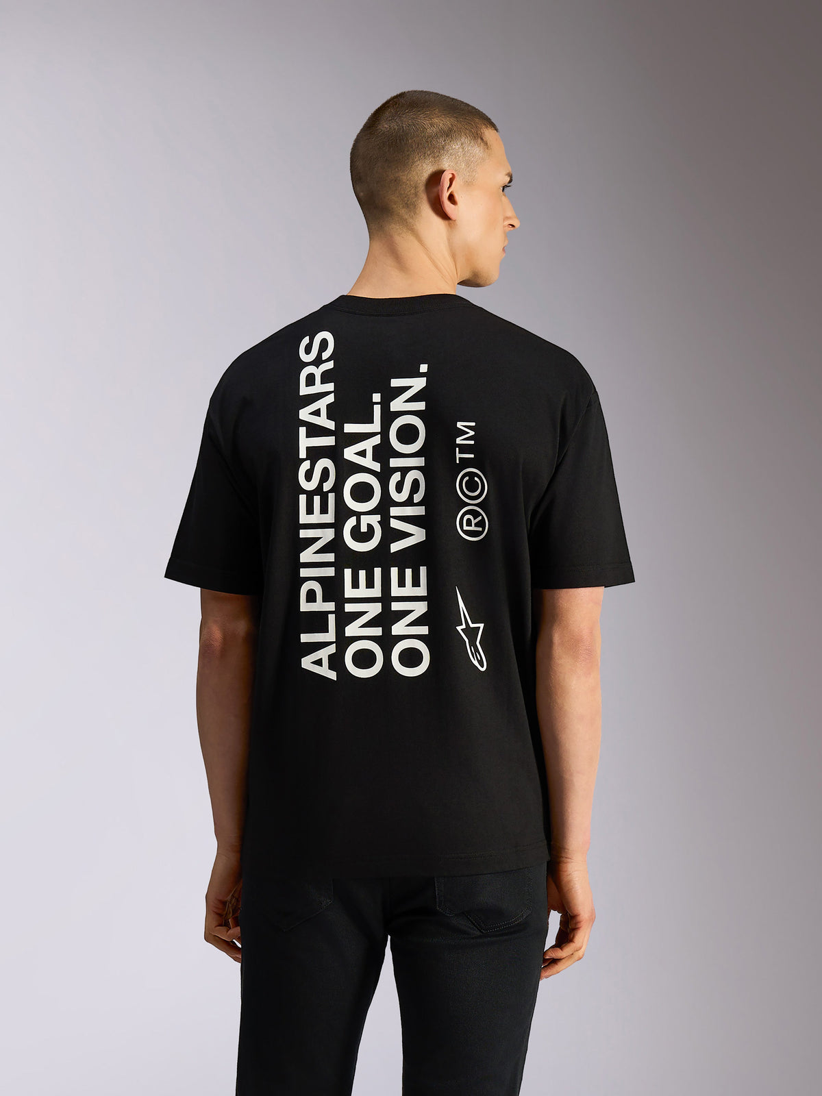 Alpinestars One Oversized CSF Tee, t-shirt de manga curta preta, texto vertical branco 'Alpinestars One Goal One Vision' nas costas, logótipo Astars lateral, corte oversized e estilo casual de desporto motorizado