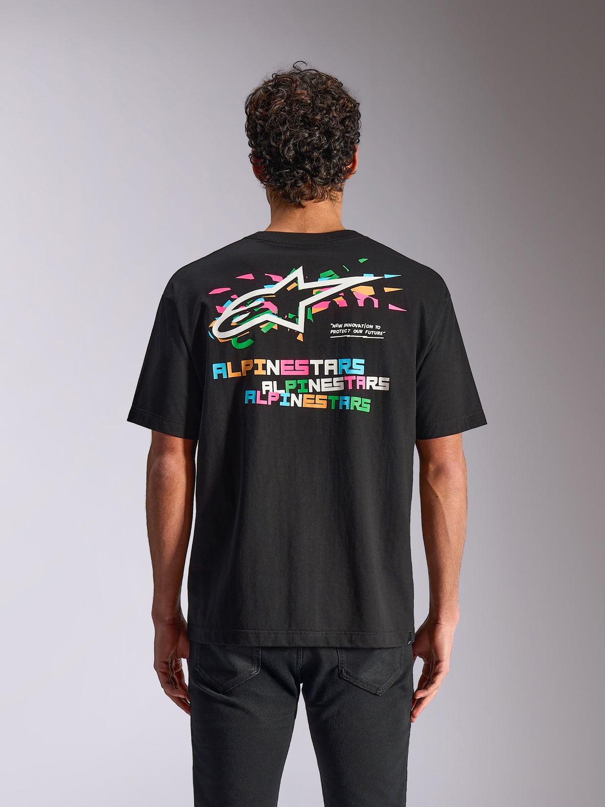 Alpinestars Wild Oversized CSF Tee, t-shirt de manga curta, preta, vista traseira mostrando o logótipo Astars multicolorido vibrante e elementos gráficos, streetwear casual de desportos motorizados