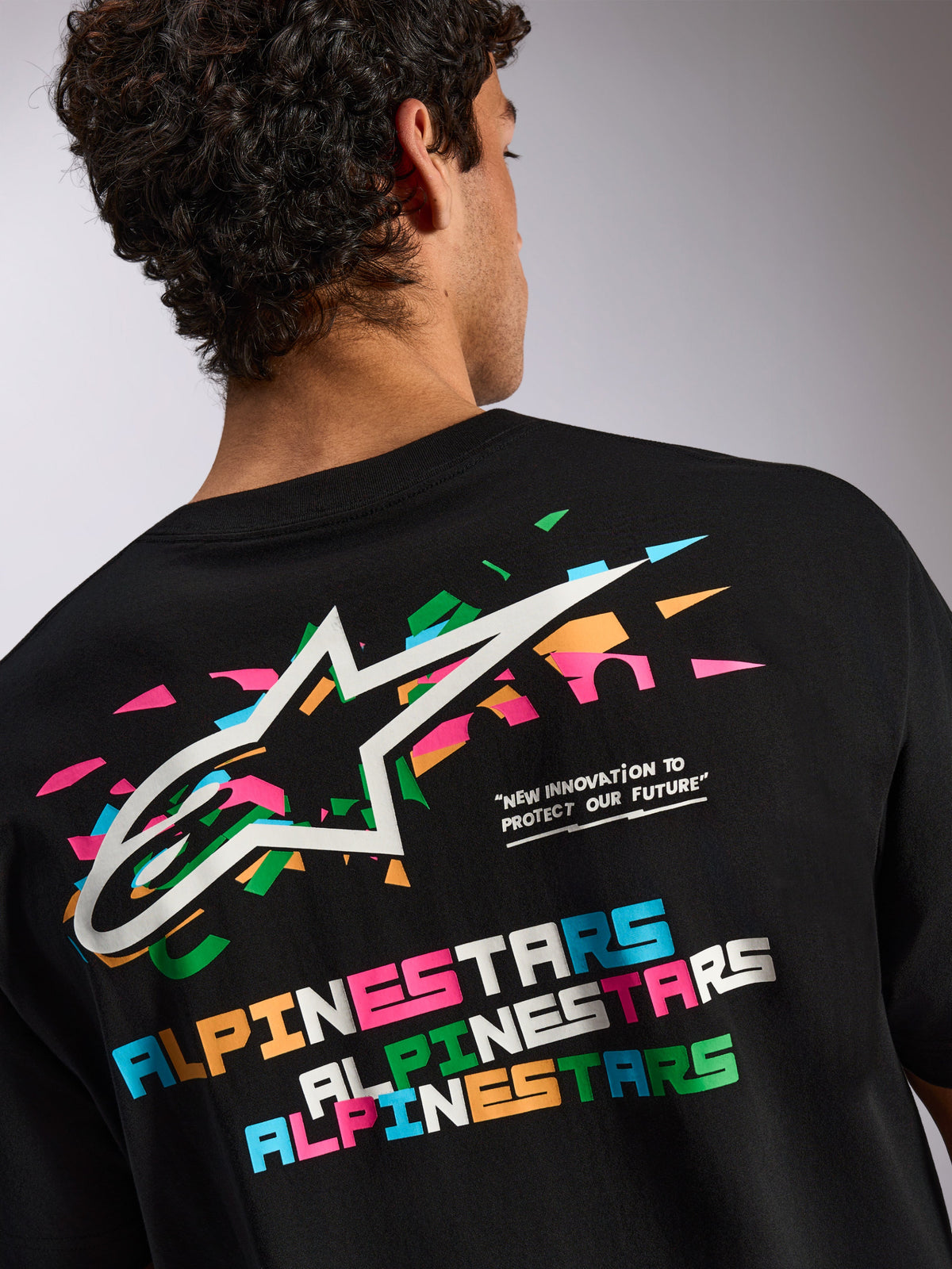 Alpinestars Wild Oversized CSF Tee, t-shirt de manga curta preta, gráfico grande nas costas com o logótipo Astars multicolorido vibrante e tipografia, roupa desportiva casual