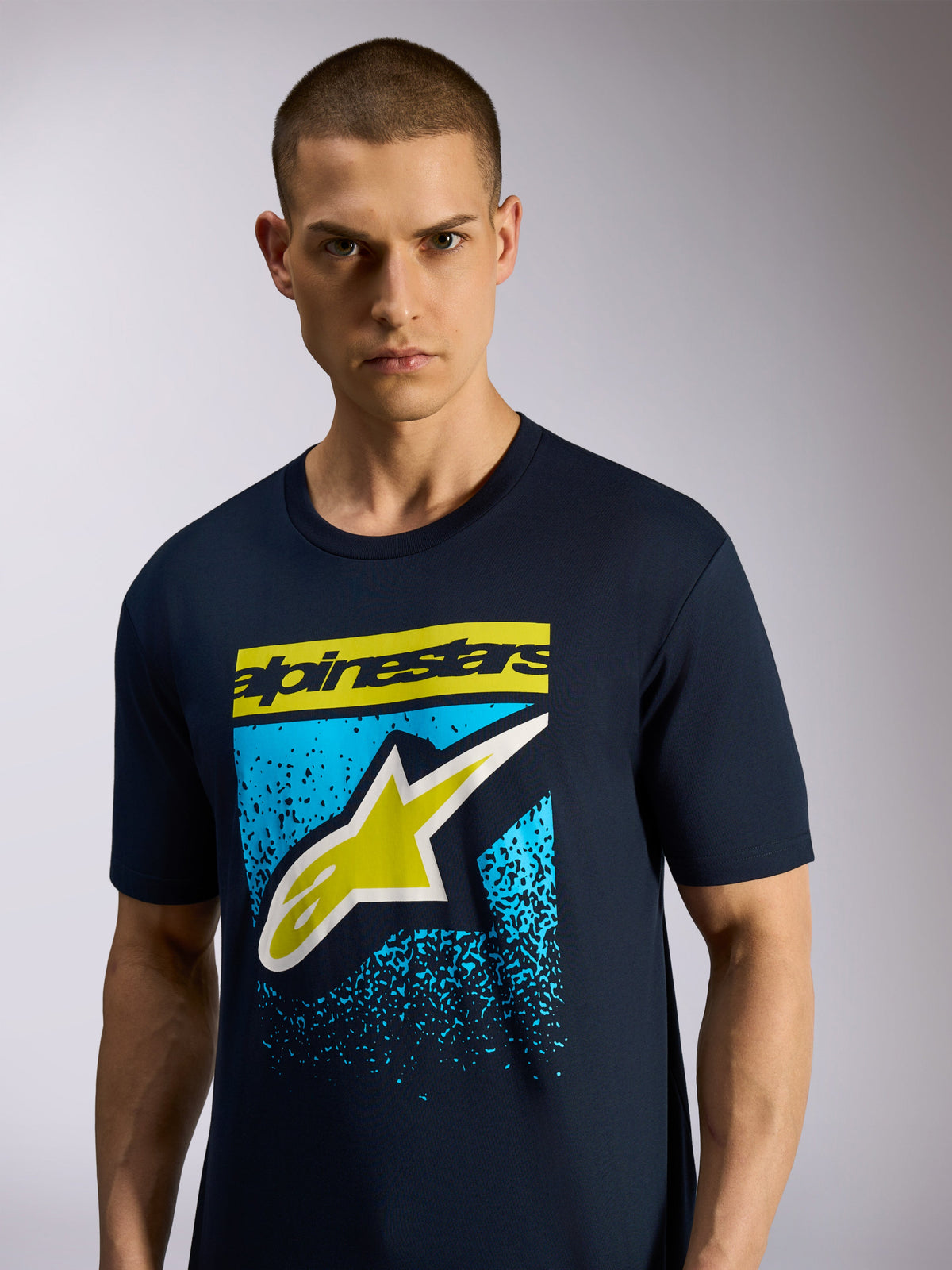 T-shirt Alpinestars Noka CSF, camisola de manga curta, azul-marinho, apresenta logótipo Astars frontal com lettering amarelo e gráfico azul salpicado, vestuário desportivo casual de motorsport