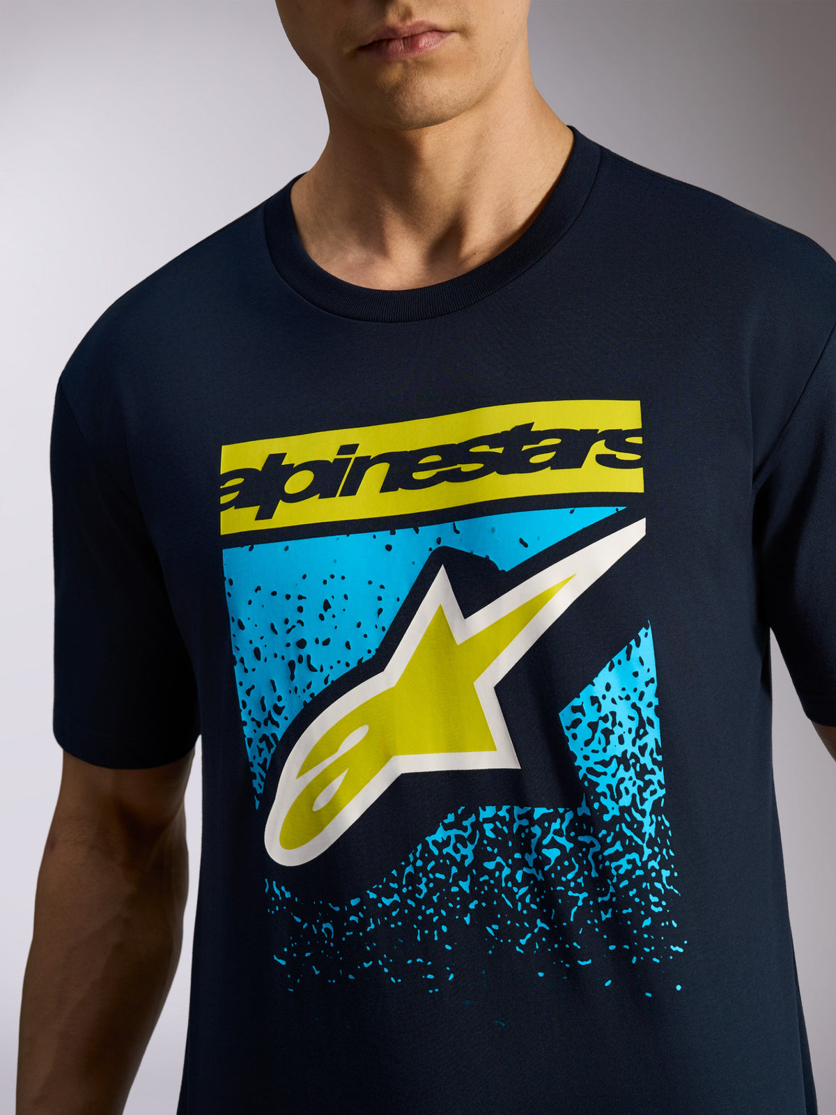 T-shirt Alpinestars Noka CSF, t-shirt de manga curta em azul marinho, logótipo Alpinestars e símbolo A-star em amarelo com gráfico de gradação MX em azul, vestuário desportivo casual de motorsport
