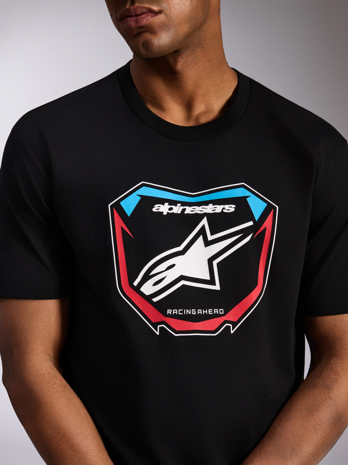 Alpinestars Plate CSF Tee, t-shirt de manga curta, preta, gráfico frontal de placa de motocross com logótipo Astars branco, detalhes em vermelho e azul e texto 'RACING AHEAD', streetwear casual inspirado no desporto motorizado