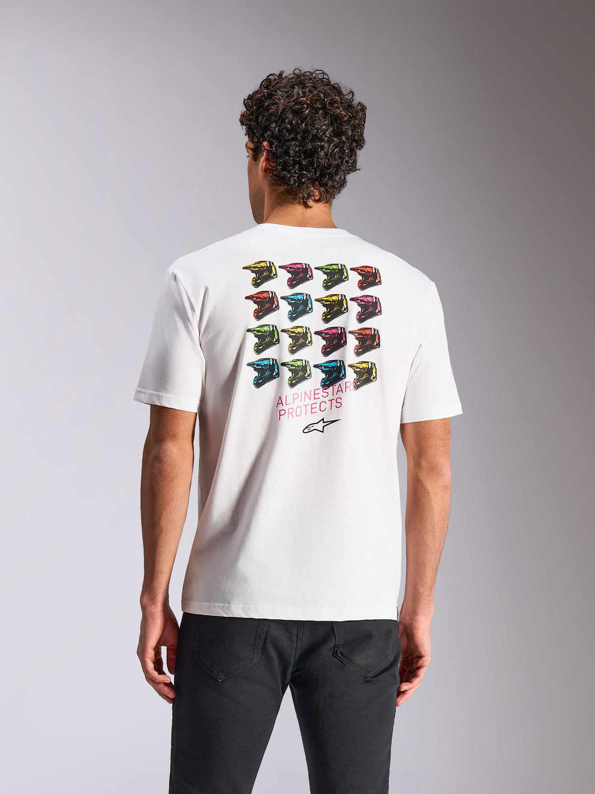 Alpinestars Pop Helmet CSF Tee, t-shirt de manga curta branca, com grafismo colorido de uma grelha de capacetes M10 nas costas e o texto Alpinestars Protects, sportswear casual