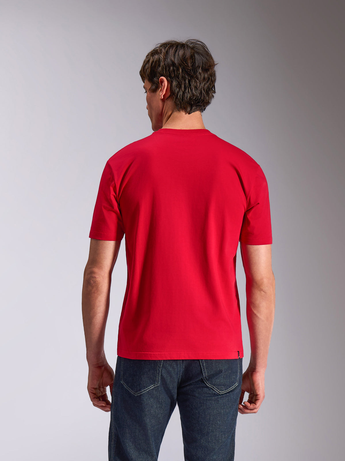 Alpinestars Authority CSF Tee, t-shirt de manga curta, vermelha, vista traseira em modelo a usar calças de ganga escuras, streetwear casual de desportos motorizados