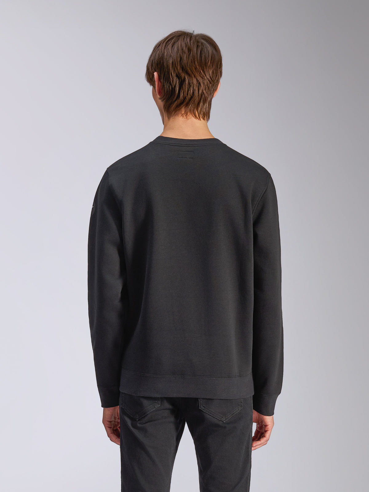 Alpinestars Bettern Crew, camisola de gola redonda, preta, vista traseira no modelo, com punhos e bainha canelados, streetwear casual de desportos motorizados
