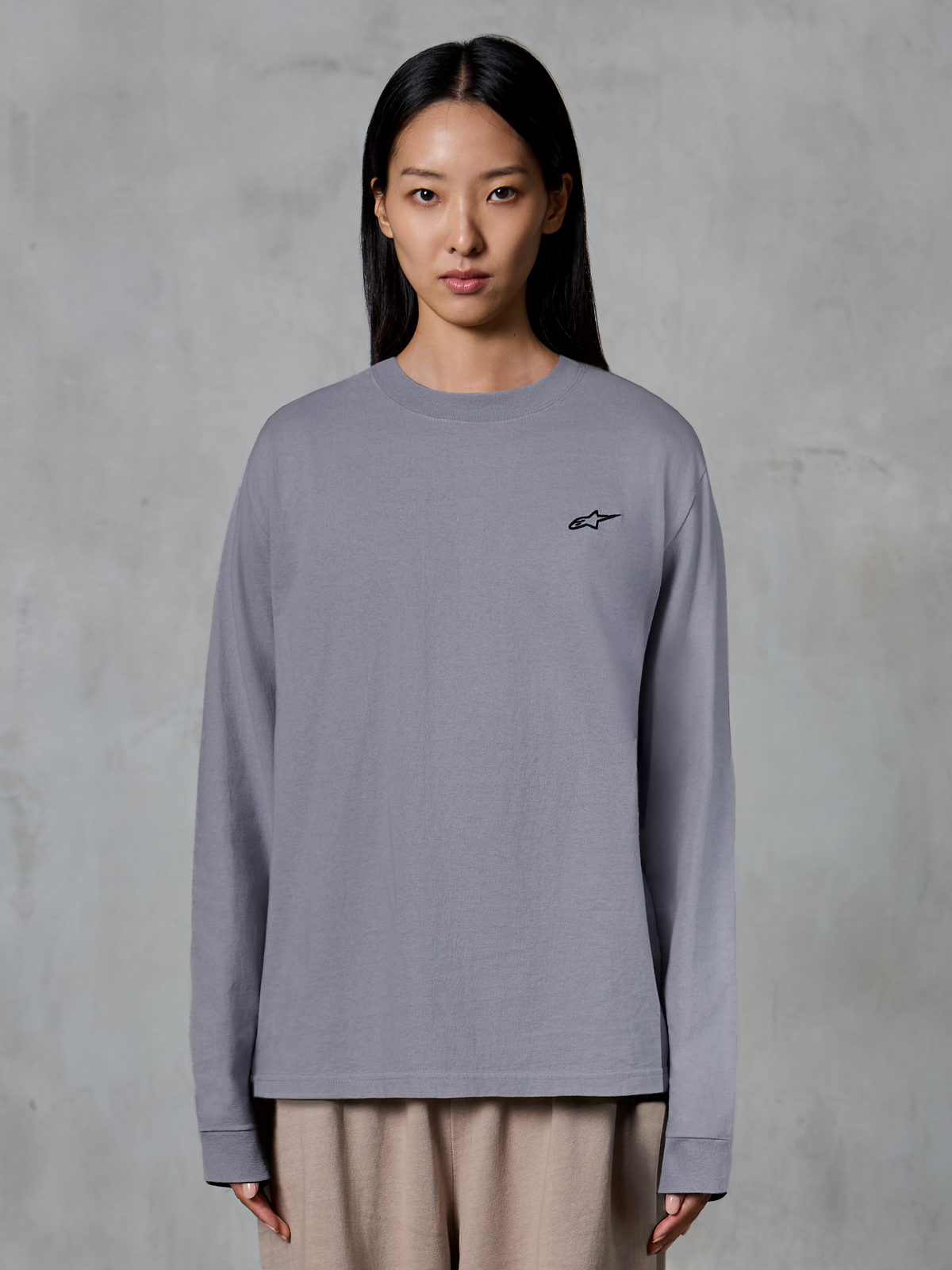 Alpinestars Essentials Ageless LS Tee, t-shirt de manga comprida, prateada, com um pequeno logótipo de estrela preto no peito, ajuste relaxado, algodão orgânico premium, streetwear casual inspirado no desporto motorizado