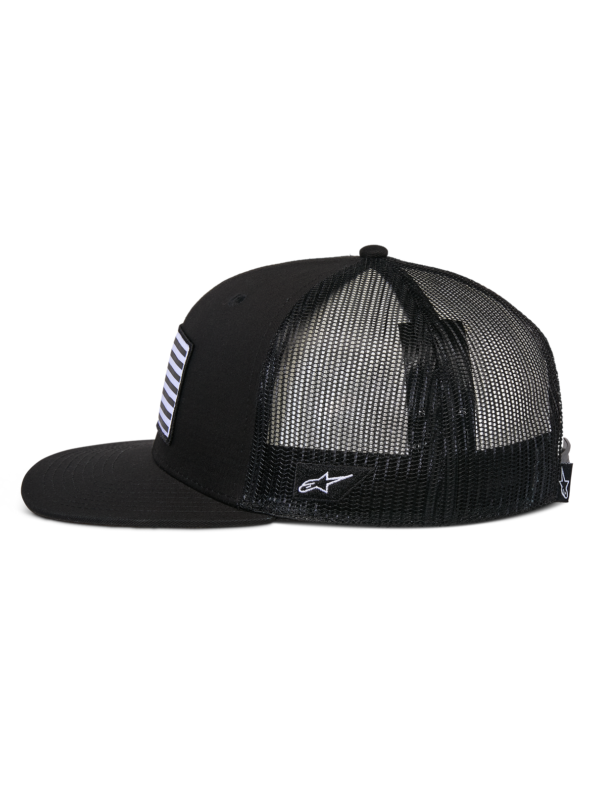 Boné Alpinestars Flag Flat Trucker, perfil lateral, preto, aba plana e coroa estruturada, parte traseira em malha de poliéster respirável, remendo frontal de bandeira e logótipo lateral bordado a branco, acessório casual inspirado no desporto motorizado
