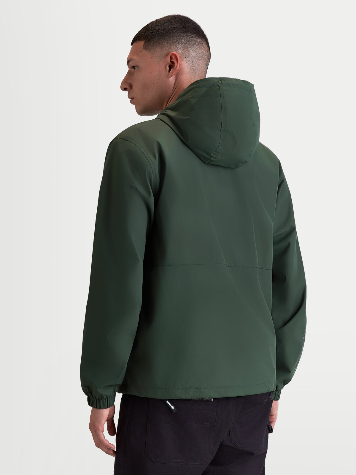 Alpinestars Speeder Resolve, casaco corta-vento de sportswear leve para uso urbano, verde, vista traseira num modelo realçando o design limpo das costas e os punhos elásticos, 100% poliéster com forro em malha.