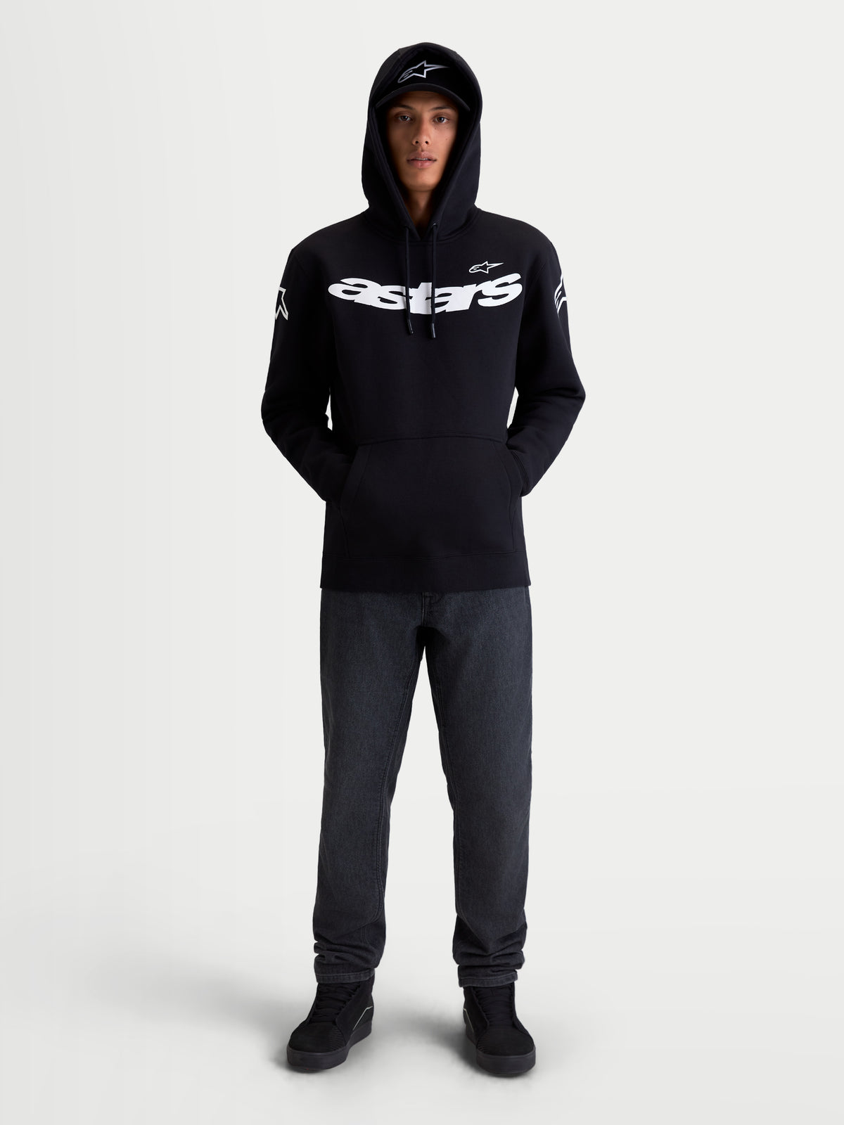 Alpinestars Camisola com capuz Velocifier, hoodie de sportswear unissexo, preta e branca, vista frontal no modelo com logótipo Astars grande no peito e nos ombros, ideal para uso casual fora da moto, mistura de algodão e poliéster reciclado.