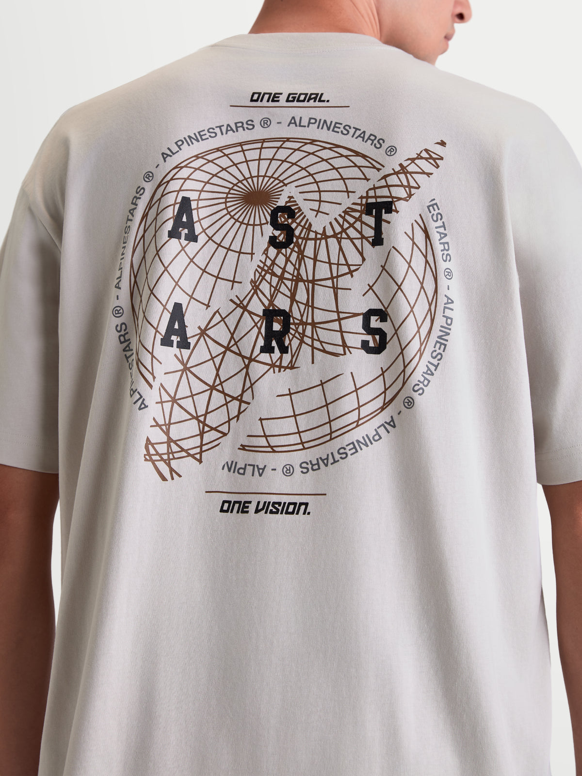 Alpinestars T-Shirt Latitude Oversized CSF, t-shirt de manga curta cinzenta, vista traseira num modelo com gráfico de globo grande, marca ASTARS e lemas One Goal e One Vision, casual sportswear em mistura de algodão e poliéster.