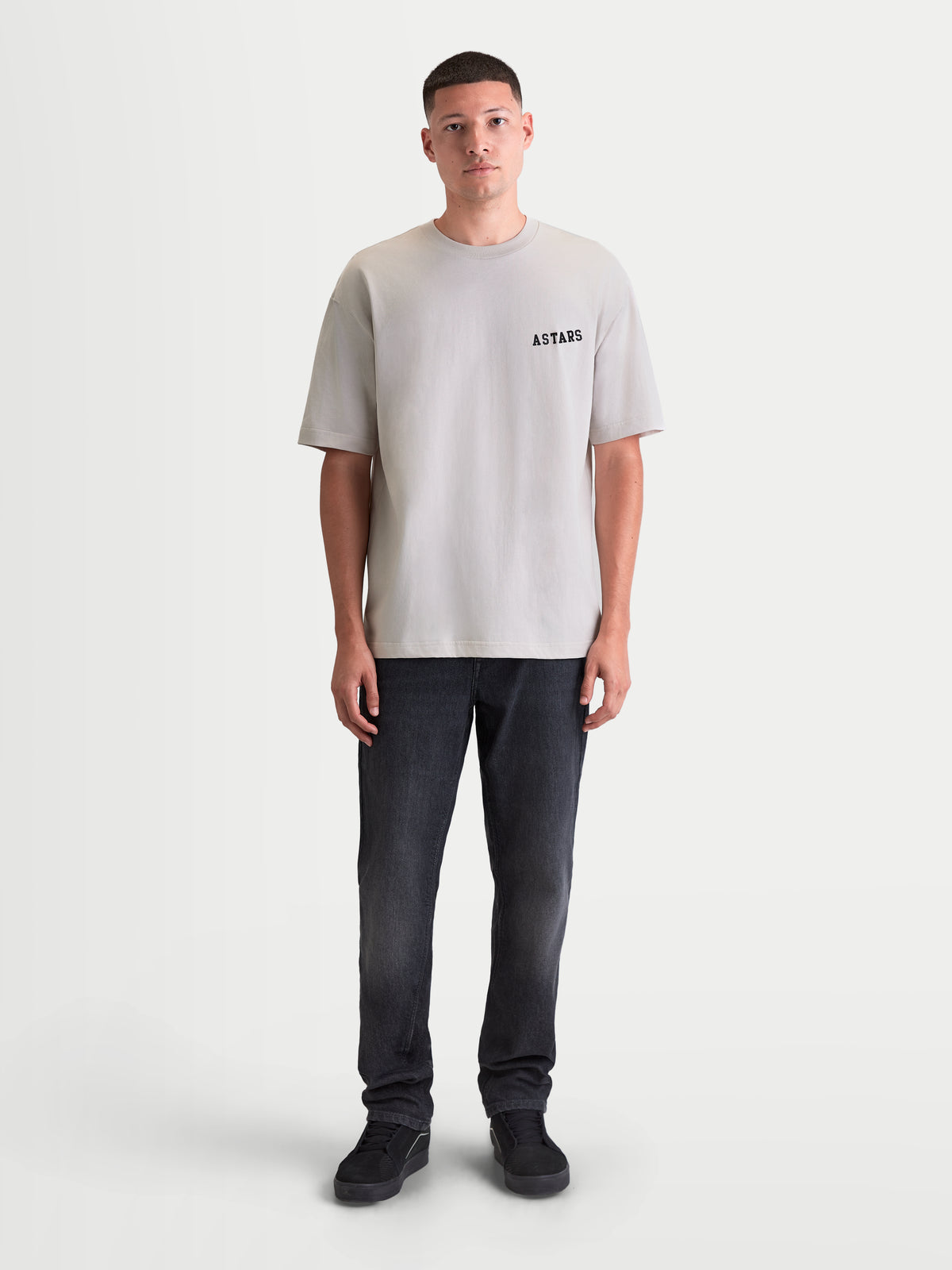 Alpinestars Latitude Oversized CSF Tee, t-shirt de manga curta para homem em cinzento-cimento, corte oversized descontraído com logótipo ASTARS no peito, mistura de algodão e poliéster, vista frontal de corpo inteiro em modelo.