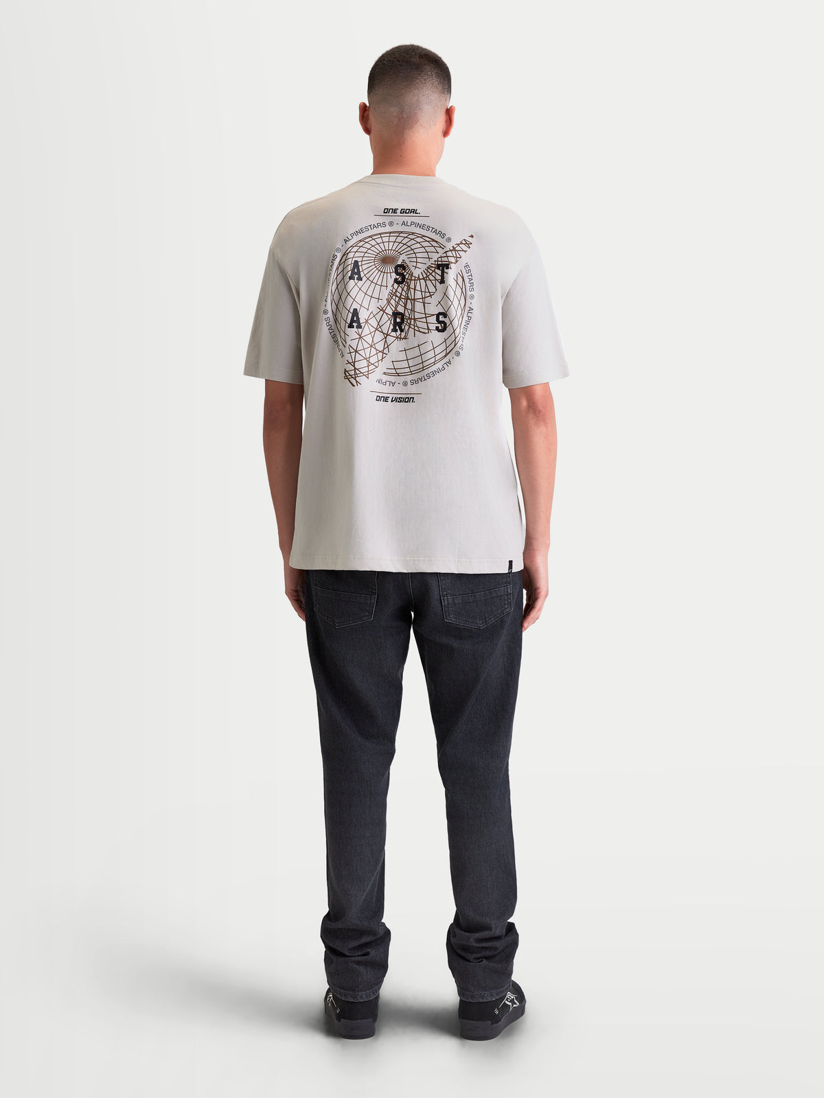 Alpinestars T-Shirt Latitude Oversized CSF, t-shirt de manga curta para homem em cinzento cimento, vista traseira num modelo com gráfico de globo e logótipo nas costas, corte oversized descontraído, sportswear casual
