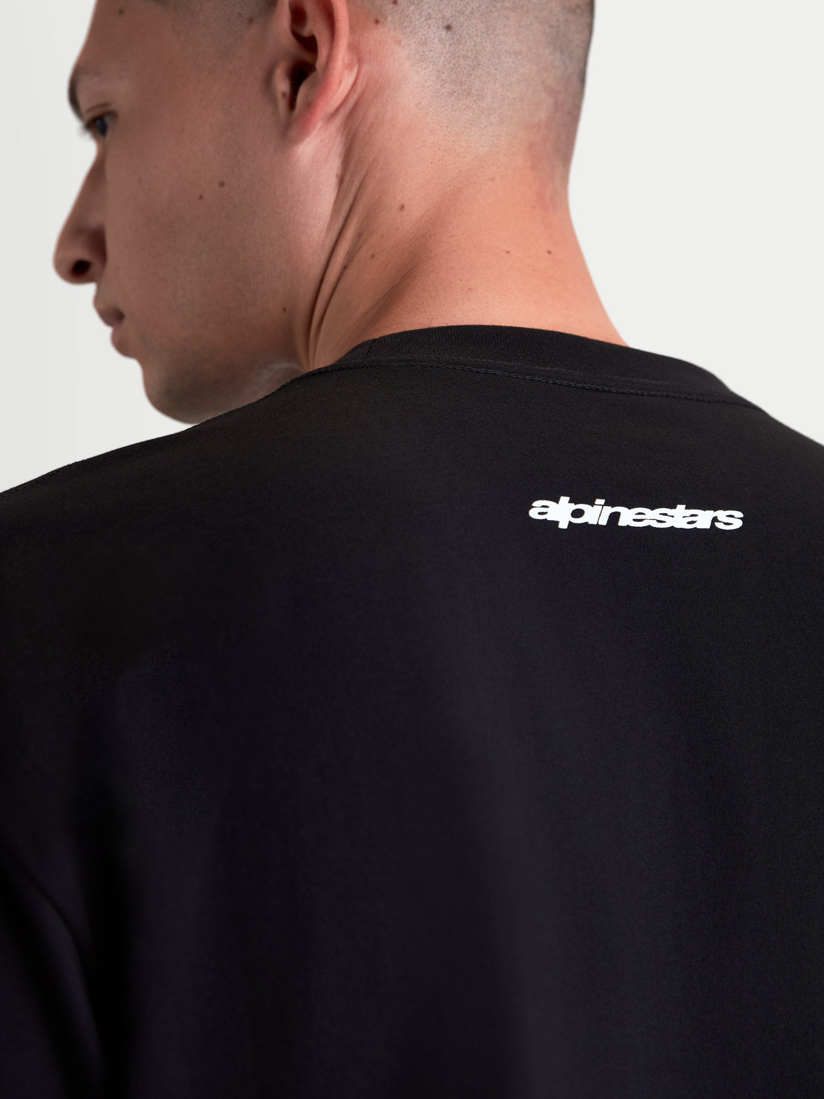 Alpinestars T-shirt Prelude Oversized CSF, t-shirt de manga curta unissexo preta, pormenor do logótipo Alpinestars branco na parte superior das costas, estilo casual sportswear.