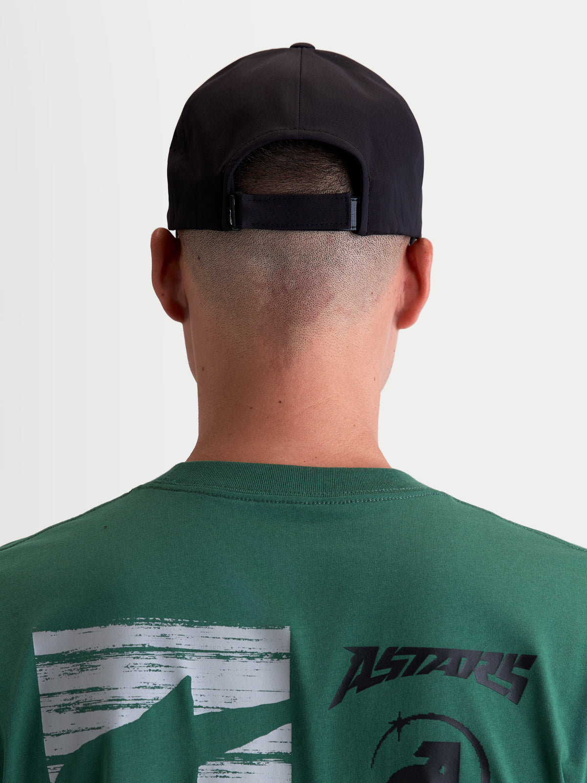 Alpinestars Algo Perf Adjustable Hat, boné de sportswear preto inspirado no motorsport, vista traseira no modelo mostrando o fecho ajustável, construção em tecido técnico, unissexo.