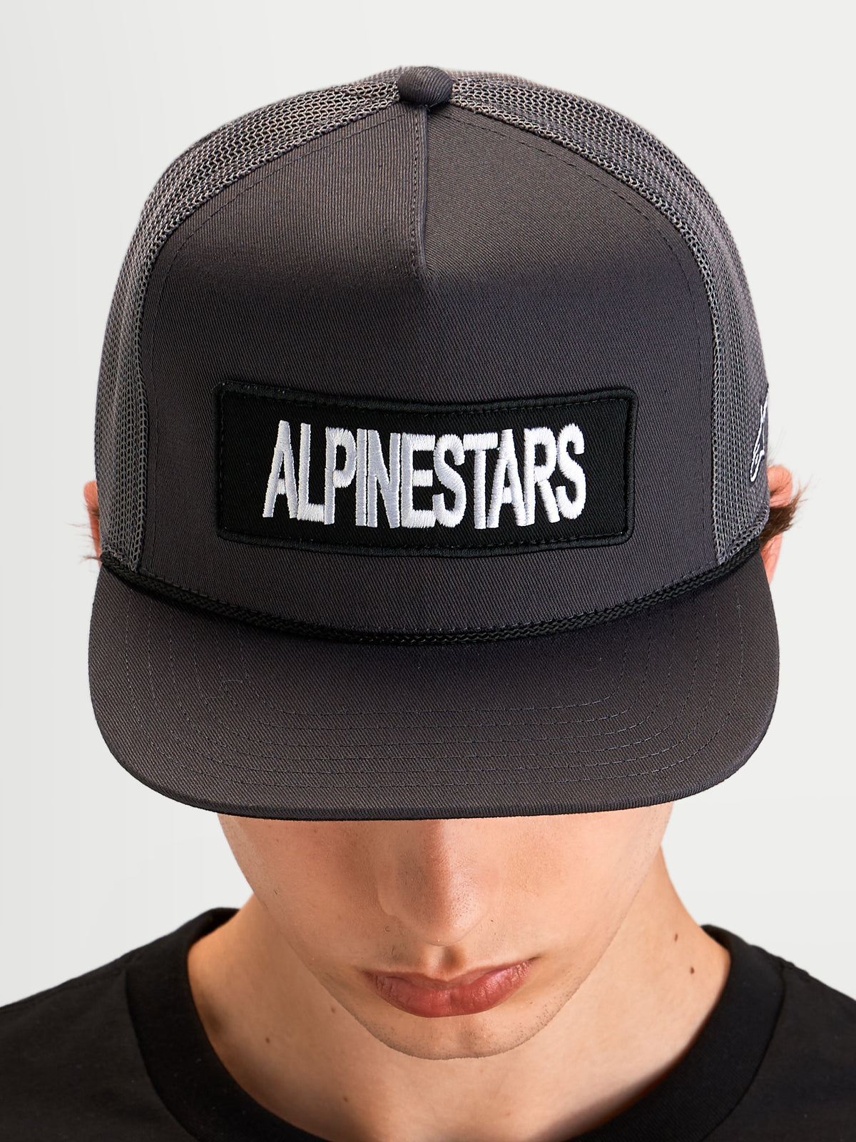 Alpinestars Boné Trucker Ten, boné desportivo de aba plana, cinzento escuro, com patch frontal do logótipo Alpinestars e coroa em malha estruturada num modelo