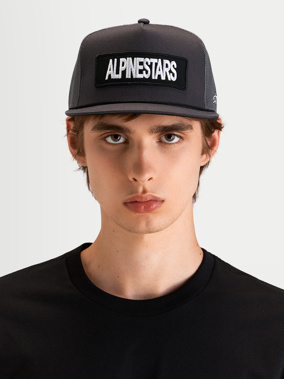 Alpinestars Boné Trucker Ten, boné sportswear de aba plana cinzento escuro, num modelo, com coroa estruturada e patch bordado com o logótipo Alpinestars à frente