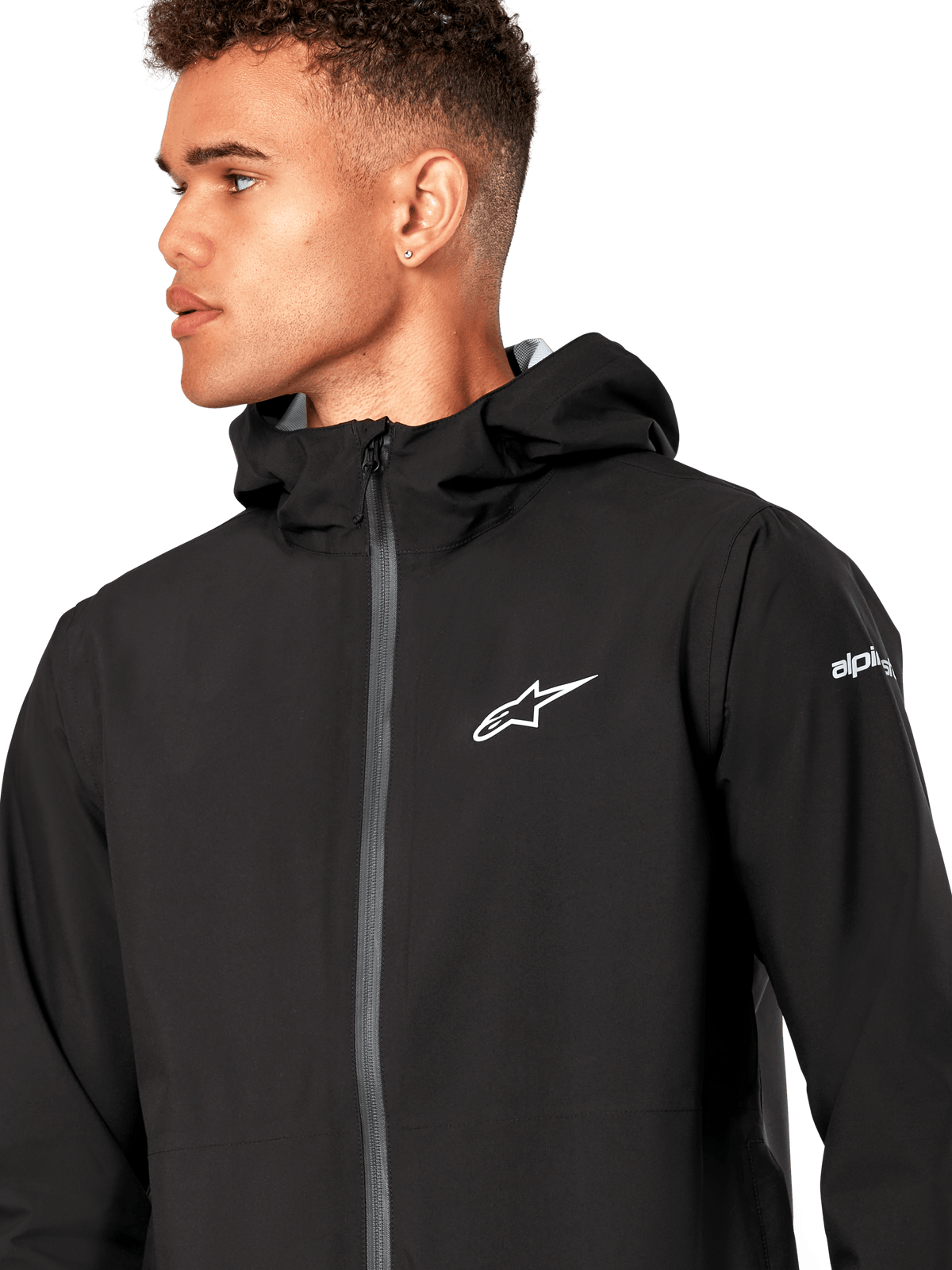 Casaco Impermeável Alpinestars Kascade, casaco impermeável preto, com logótipo de estrela branco no peito, capuz fixo e fecho frontal com zíper invertido revestido, vestuário casual de performance inspirado no desporto motorizado
