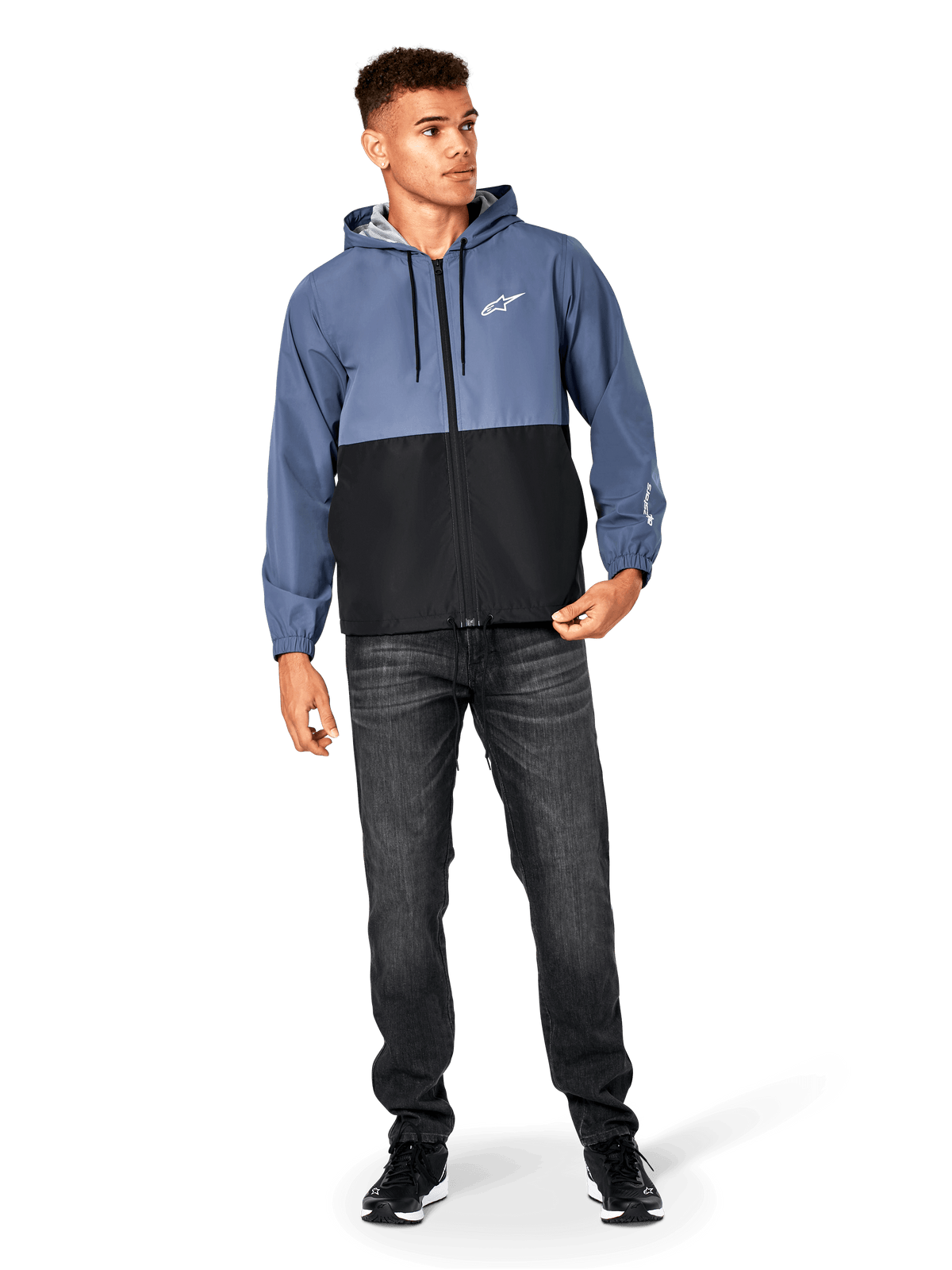 Casaco Corta-Vento Alpinestars Speeder, azul-ardósia e preto, casaco leve com capuz e forro de malha, logótipo de estrela branco no peito, usado com calças de ganga pretas e sapatilhas, design casual de streetwear motorsport