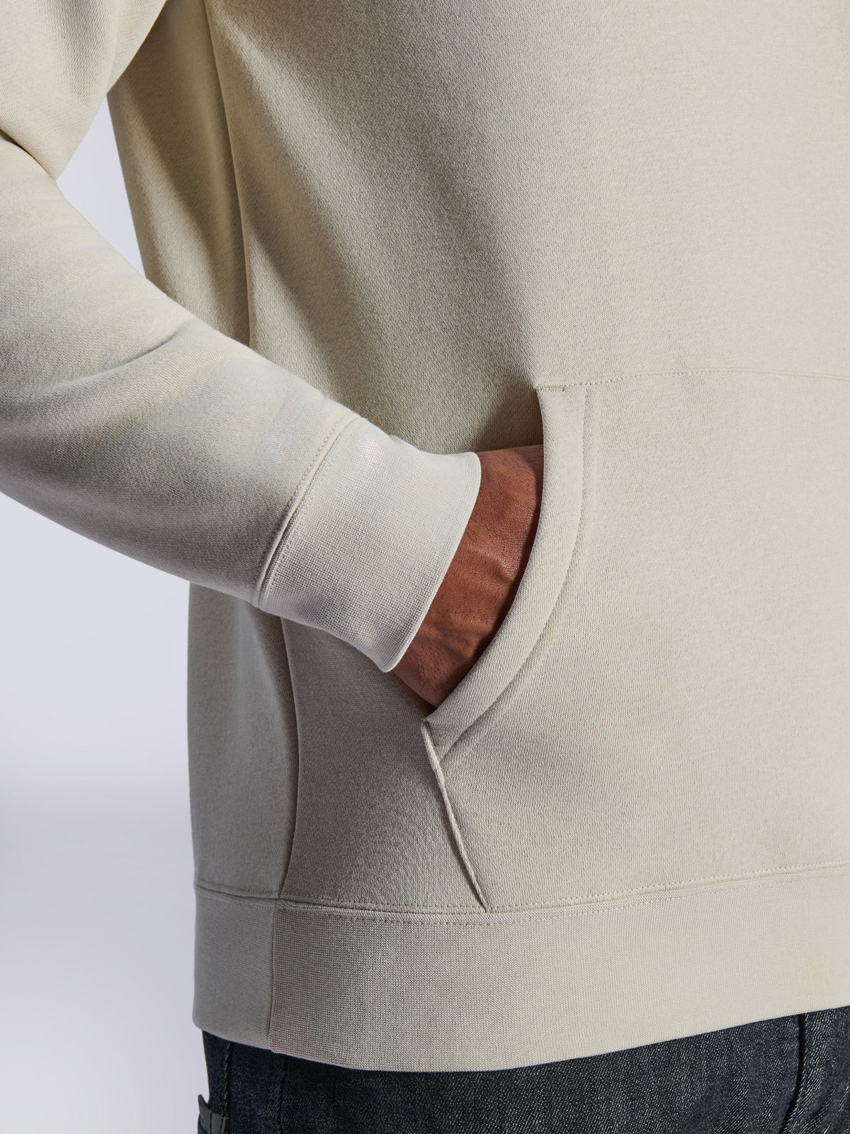Alpinestars Ageless V3 Hoodie, close-up detail of front kangaroo pocket and ribbed cuff, off-white fleece, casual motorsport-inspired streetwear