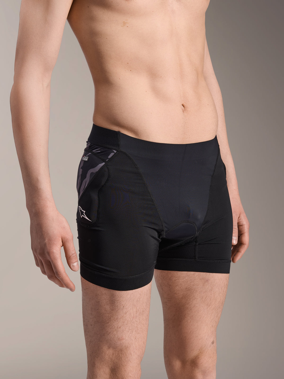 Alpinestars A-Motion Plasma Protection Boxers, black cycling base-layer shorts, featuring camo-patterned hip protector with white Astar logo, breathable mesh fabric, protective gear for mountain biking