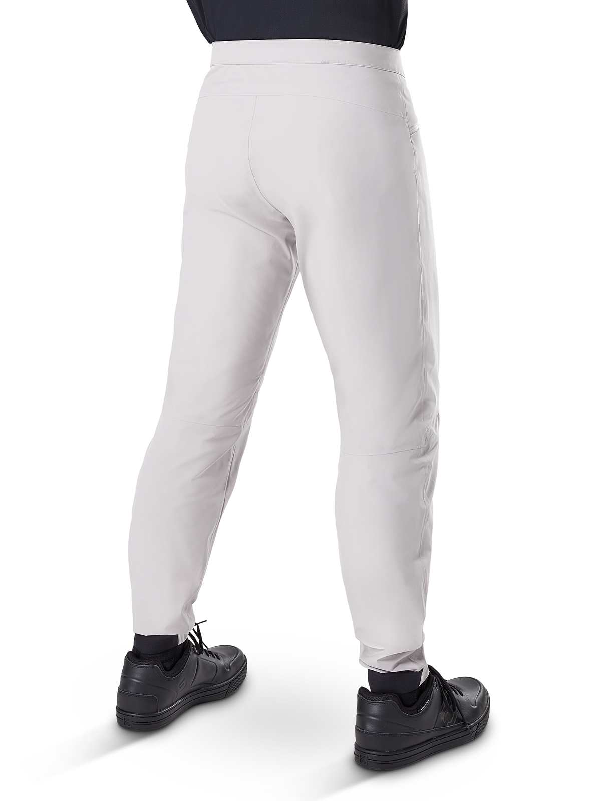 Calças Impermeáveis Alpinestars A-Dura, calças de ciclismo MTB, cinza Titanium, vista traseira mostrando as pernas afuniladas e os punhos elásticos, usadas com sapatos pretos, equipamento técnico impermeável para BTT
