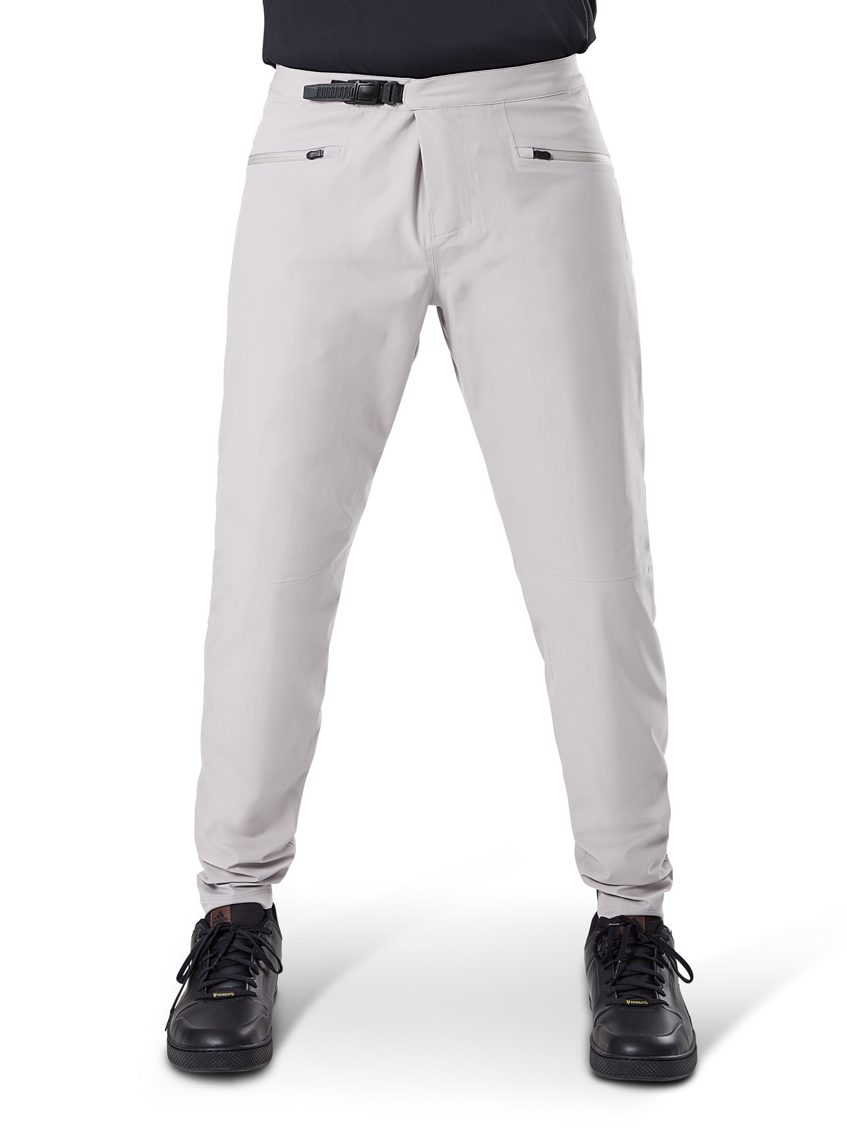 Calças Impermeáveis Alpinestars A-Dura, calças de ciclismo MTB, cinza Titanium, vista frontal, com fecho de catraca preto na cintura e dois bolsos com fecho de correr, punhos elásticos, usadas com sapatilhas pretas, equipamento técnico impermeável para mountain biking