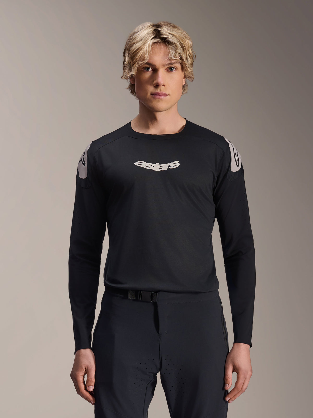Alpinestars A-Aria Polartec Elite Jersey, camisola de manga comprida para BTT, preta, com logótipo "astars" branco no peito e grafismos brancos nos ombros, equipamento de ciclismo de alta performance vestido por um modelo