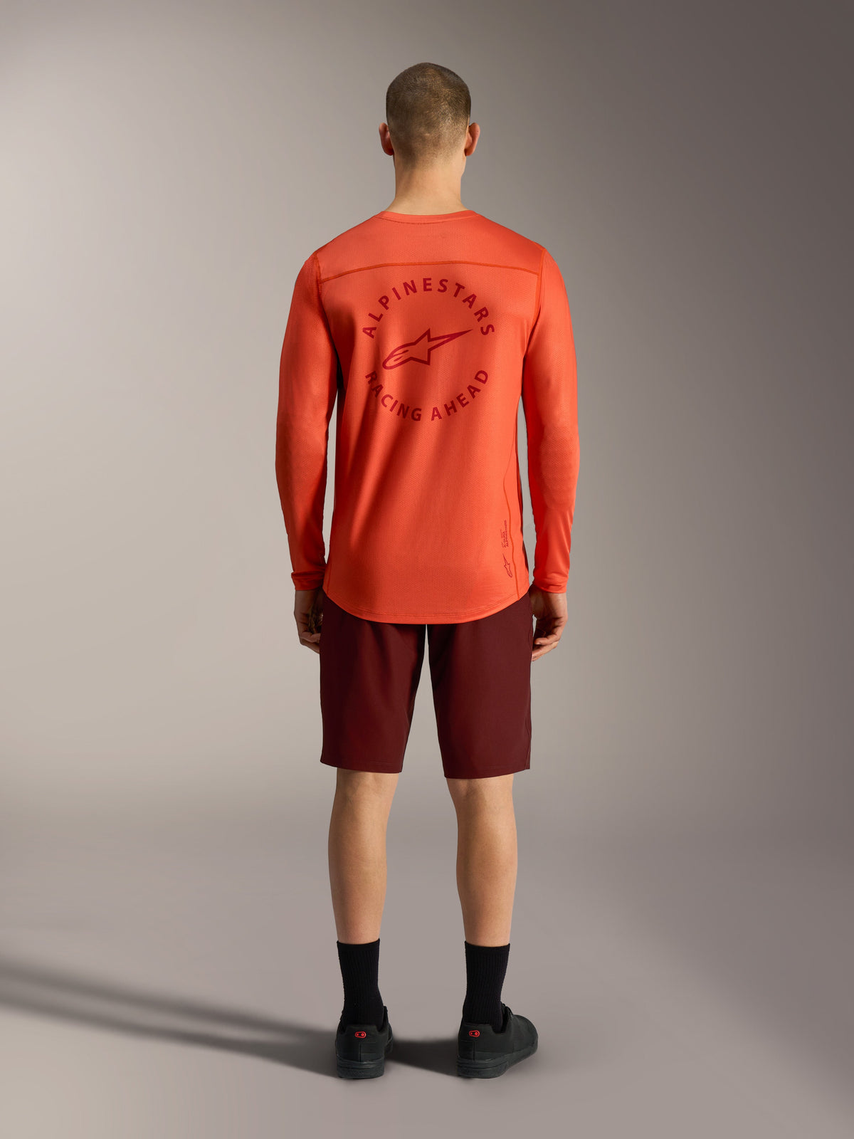 Camisola A-Dura Air LS laranja e calções Ride Bordeaux, vista traseira de equipamento de performance MTB Alpinestars.