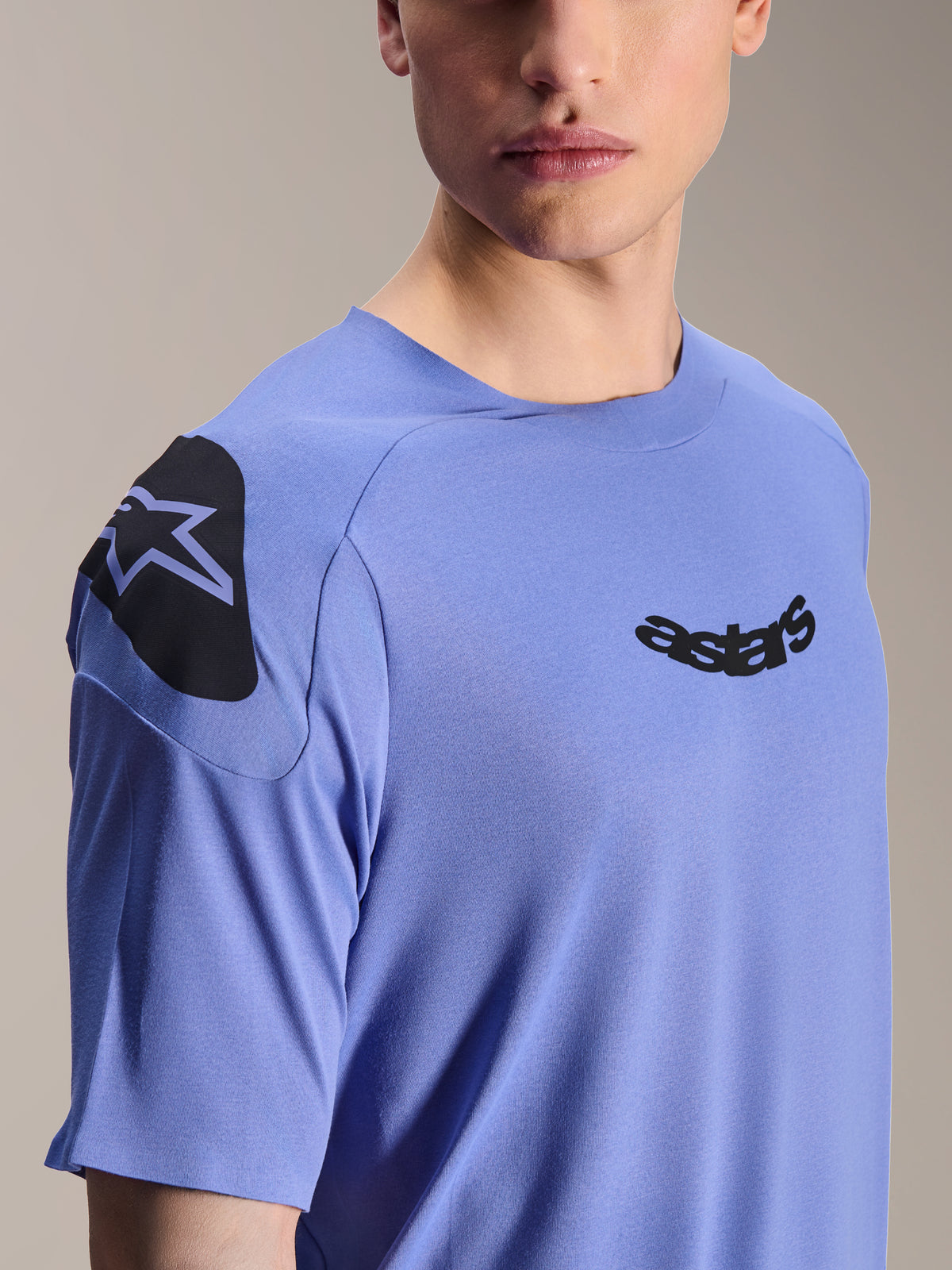 Alpinestars A-Aria Polartec Elite Jersey, camisola de manga curta para mountain bike, Baja Blue, plano aproximado do peito e ombro com logótipo astars preto e grafismo no ombro, tecido técnico de absorção de humidade para ciclismo fora de estrada