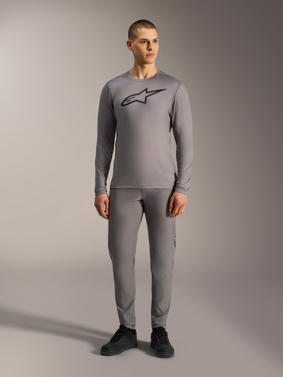Jersey Alpinestars A-Dura Ride cinzenta de manga comprida, com logótipo preto no peito e calças de MTB a condizer.