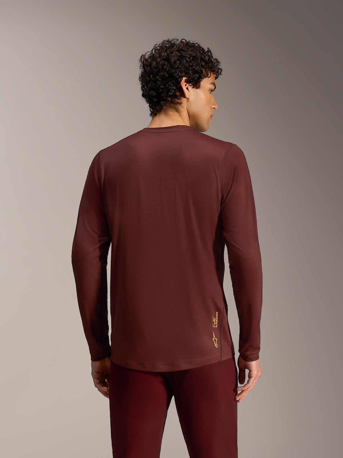 Alpinestars Bordeaux A-Dura Ride Long Sleeve Jersey, back view on a model, showing performance fabric and a dropped tail.