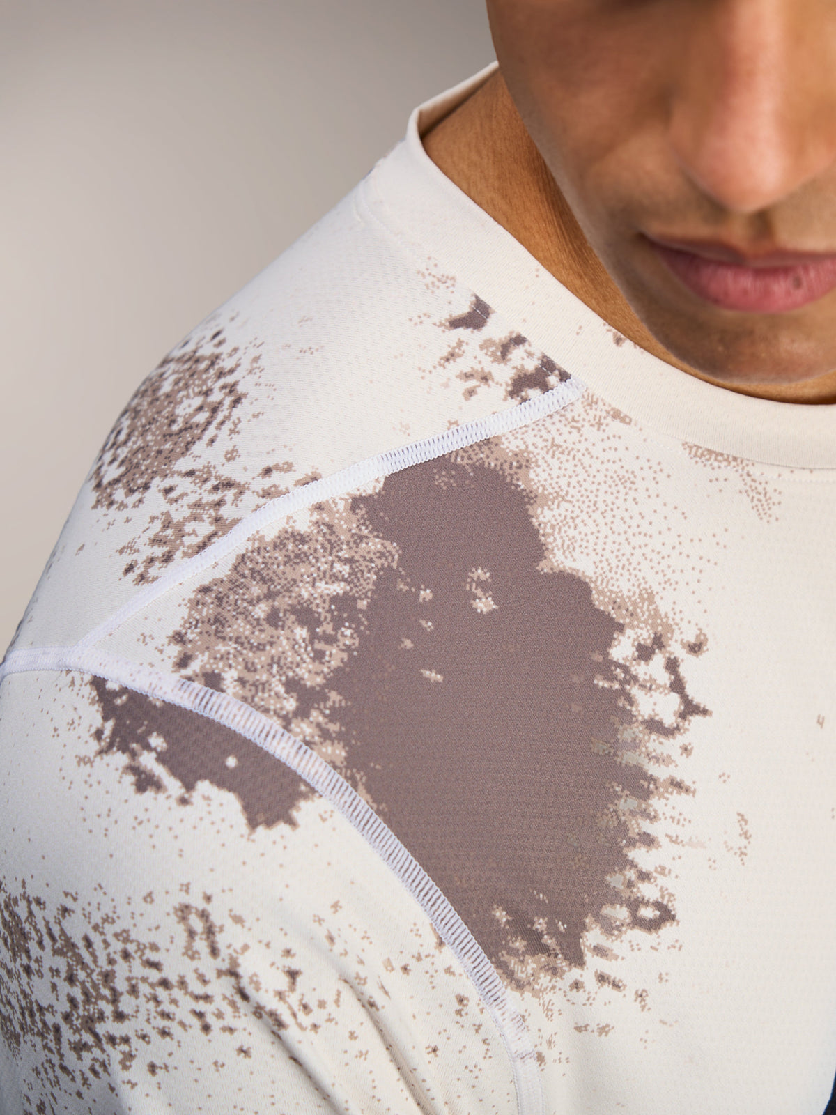 A-Dura Ride Jersey de manga comprida em Sand Camo, detalhe das costuras no ombro e tecido jacquard respirável.